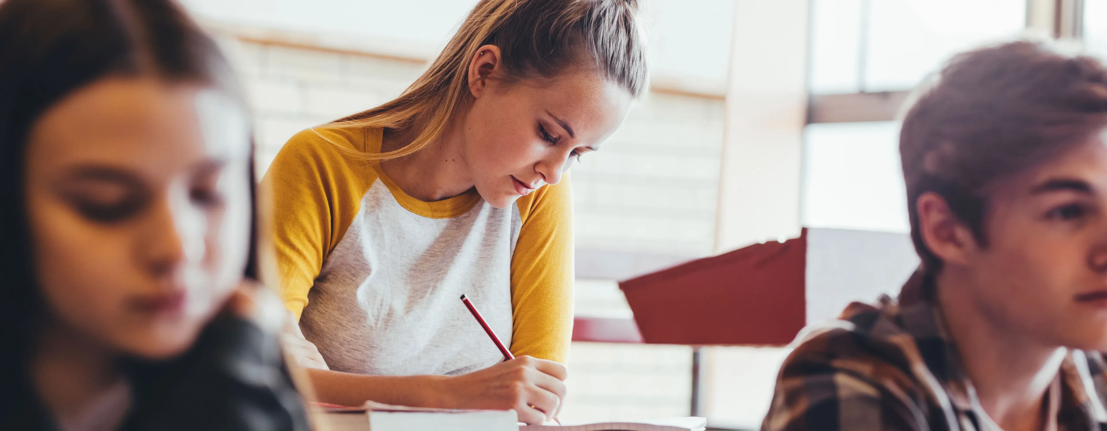 Studenter i undervisning som hører på og noterer.
