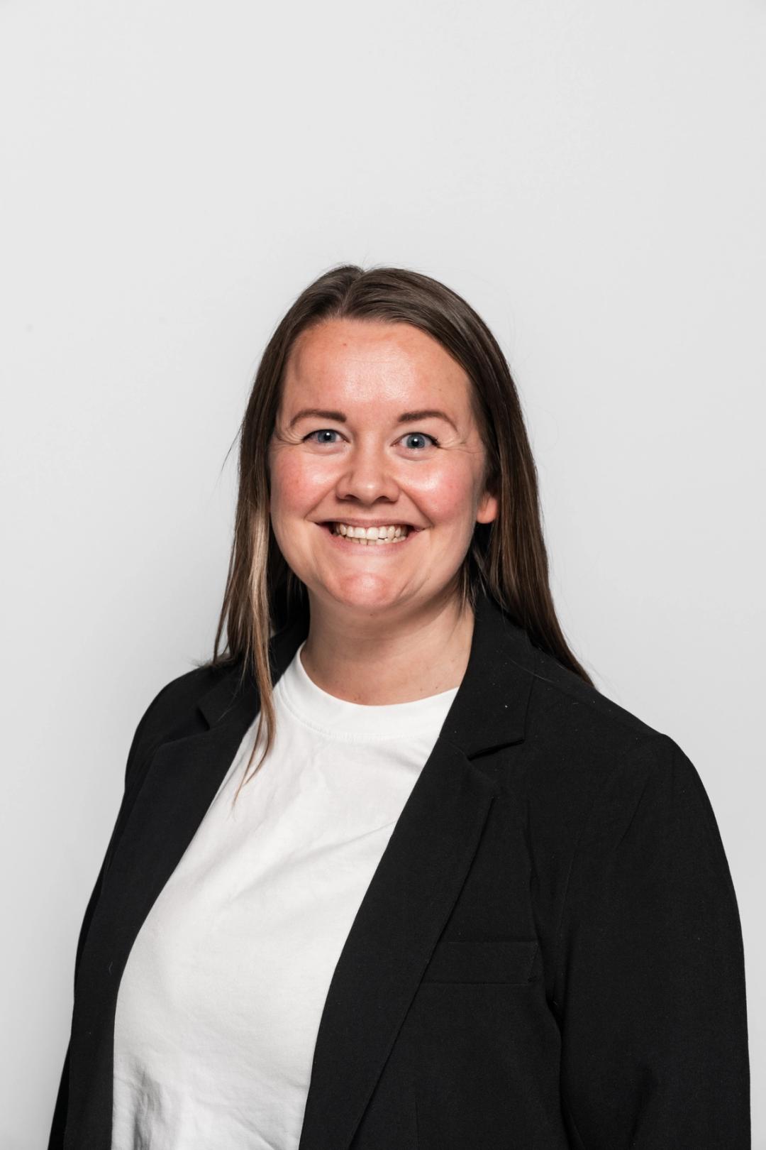 Regionsdirektør ved Sonans Oslo, Kristin Amundsen, smiler mot hvit bakgrunn