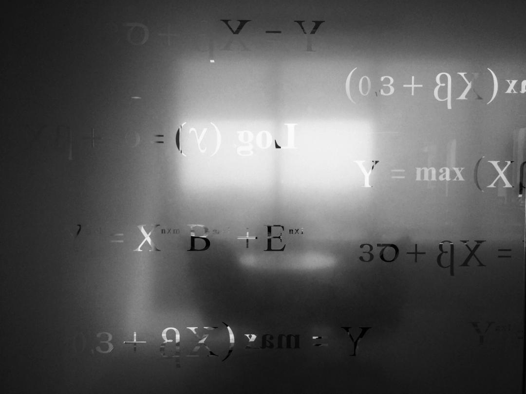 Uklare matematiske formler på en glassflate med lys som skinner gjennom i bakgrunnen.
