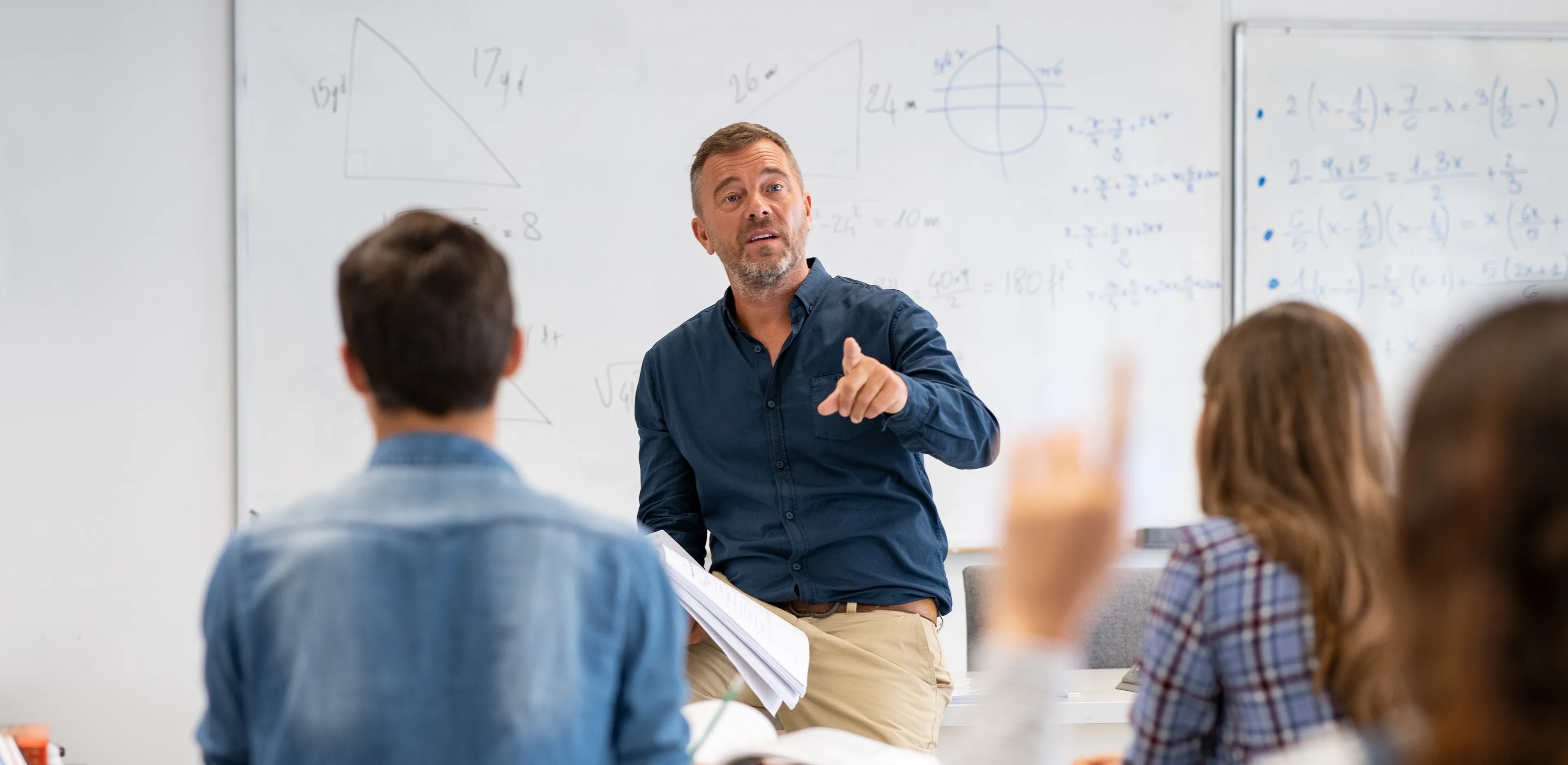 En lærer står foran en klasse og underviser i matematikk på Sonans.