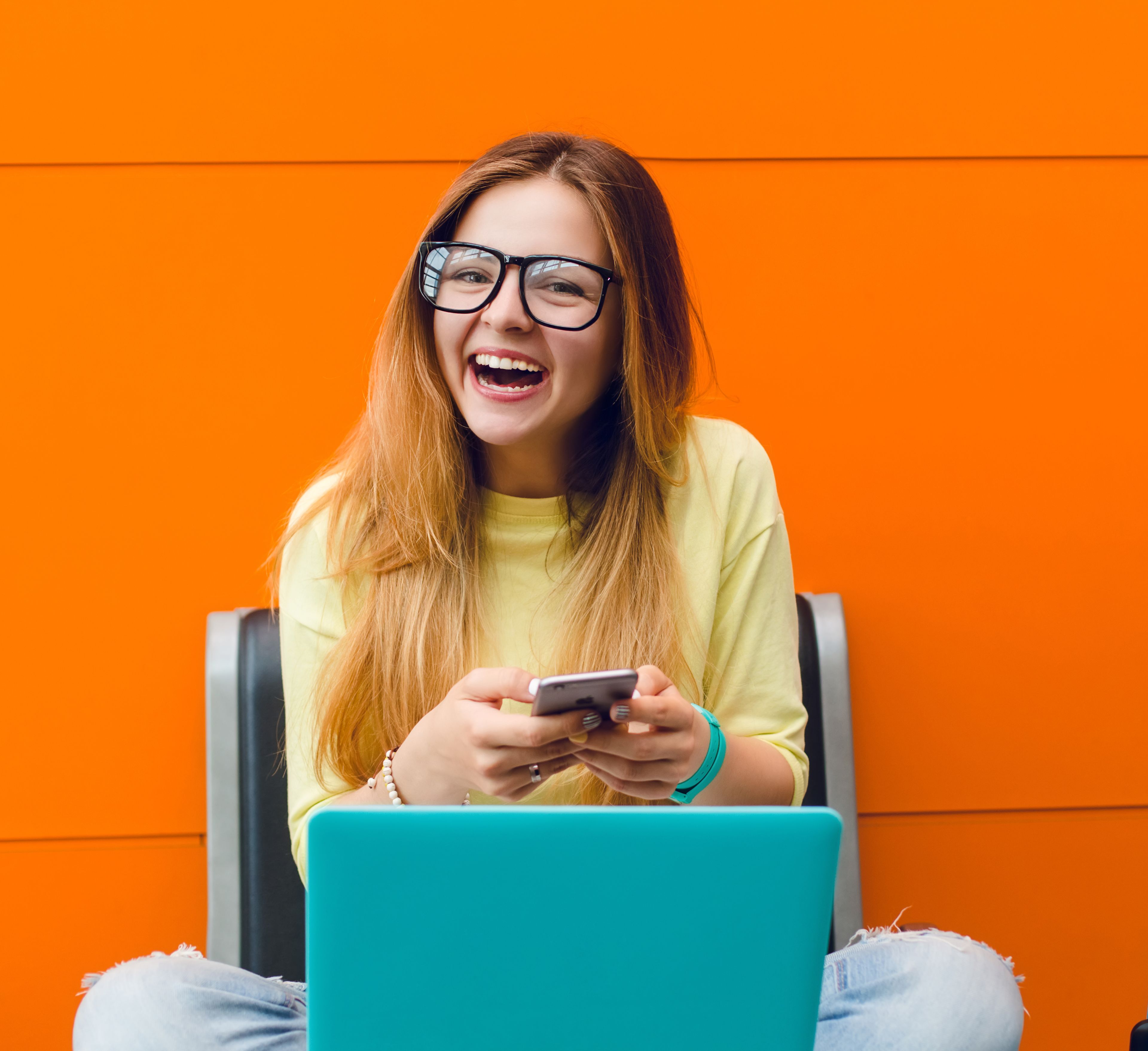 Ung kvinne sitter på en trapp med en laptop, konsentrert og fokusert på skjermen.