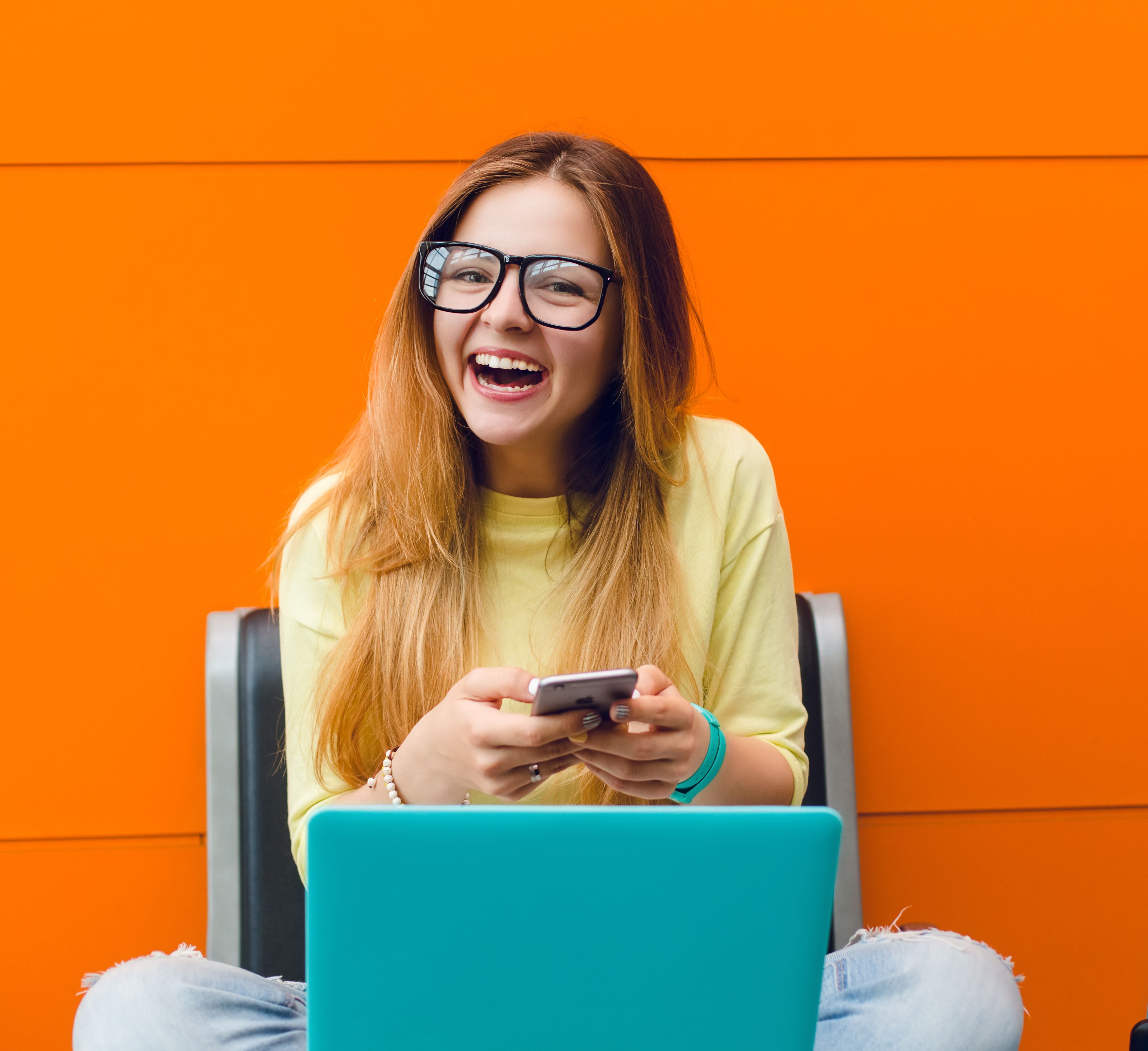 Ung kvinne sitter på en trapp med en laptop, konsentrert og fokusert på skjermen.