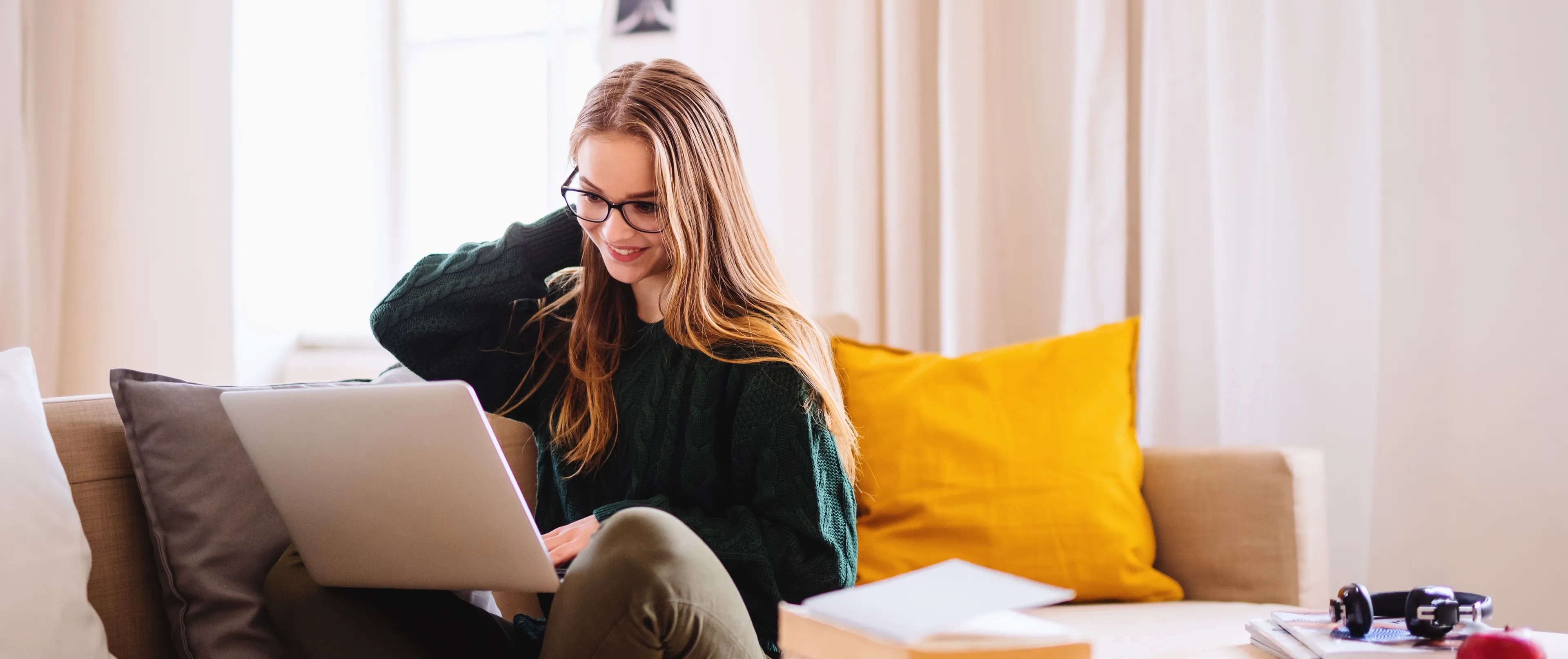 Student sitter hjemme i sofaen og har gratis rådgivningssamtale med rådgiver fra Sonans.