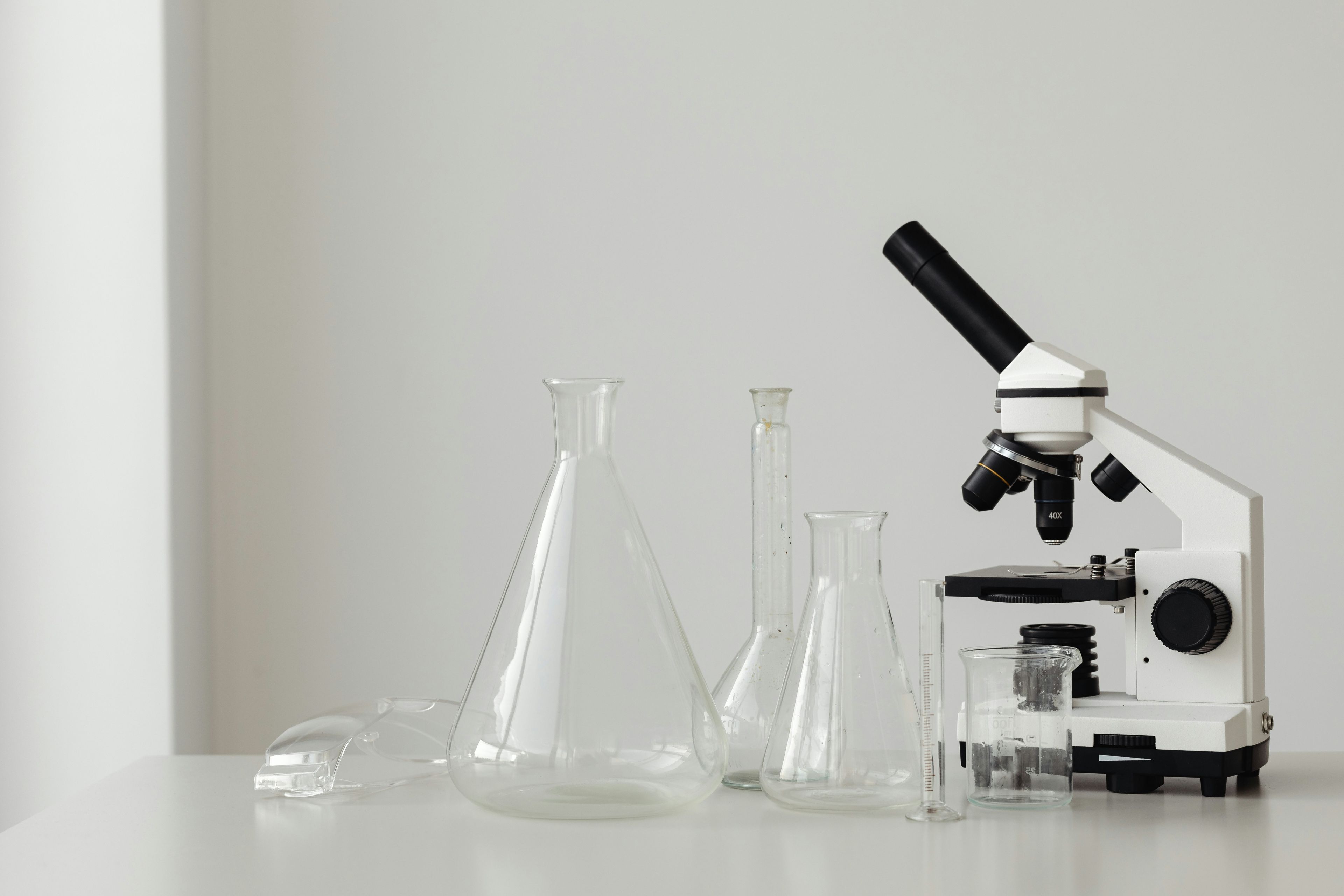 Laboratorieutstyr og mikroskop - symboliserer labøvelser i naturfag og forberedelse til muntlig-praktisk eksamen.