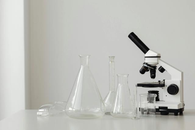 Laboratorieutstyr og mikroskop - symboliserer labøvelser i naturfag og forberedelse til muntlig-praktisk eksamen.