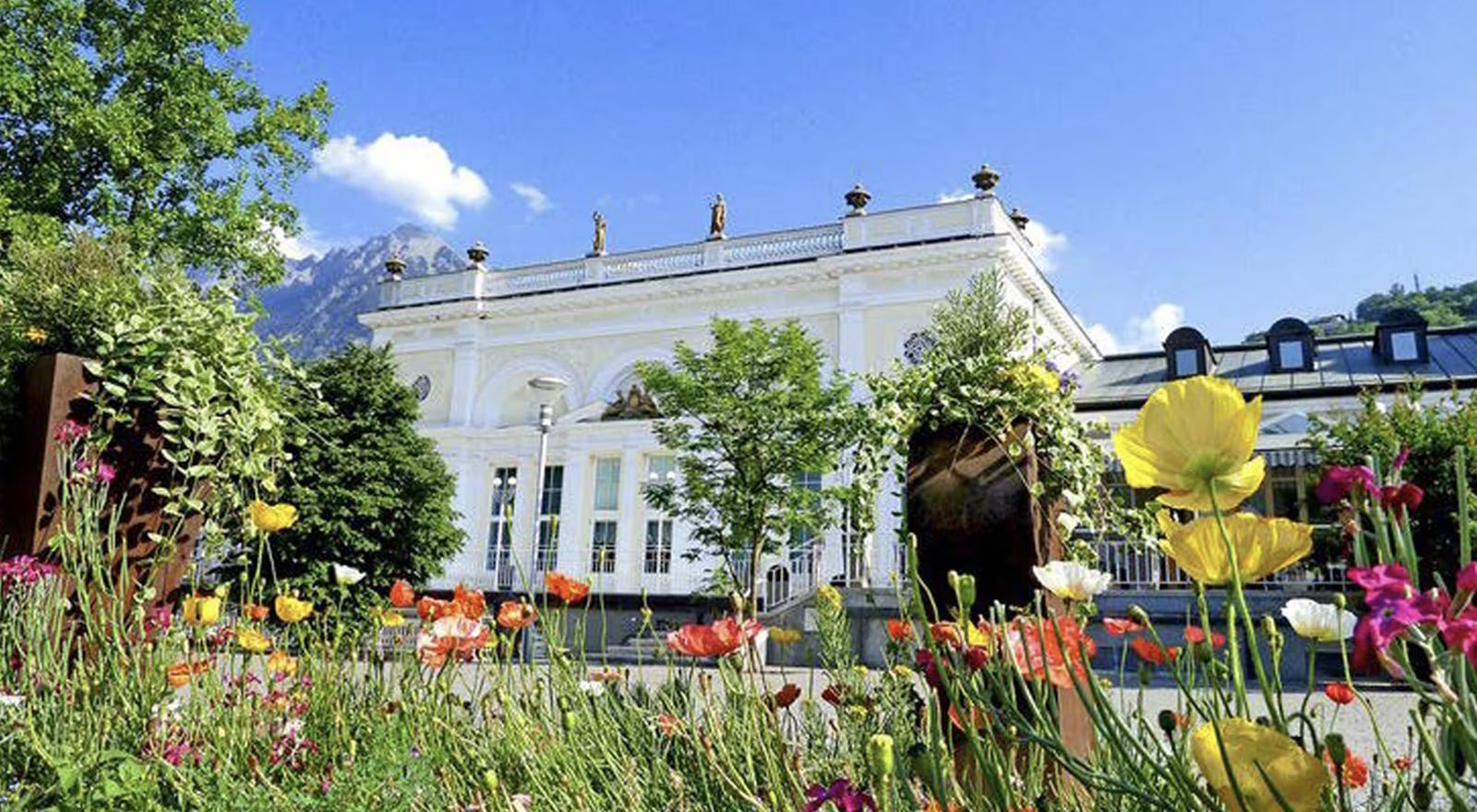 Das Kurhaus in Meran hinter einem blühenden Blumenbeet