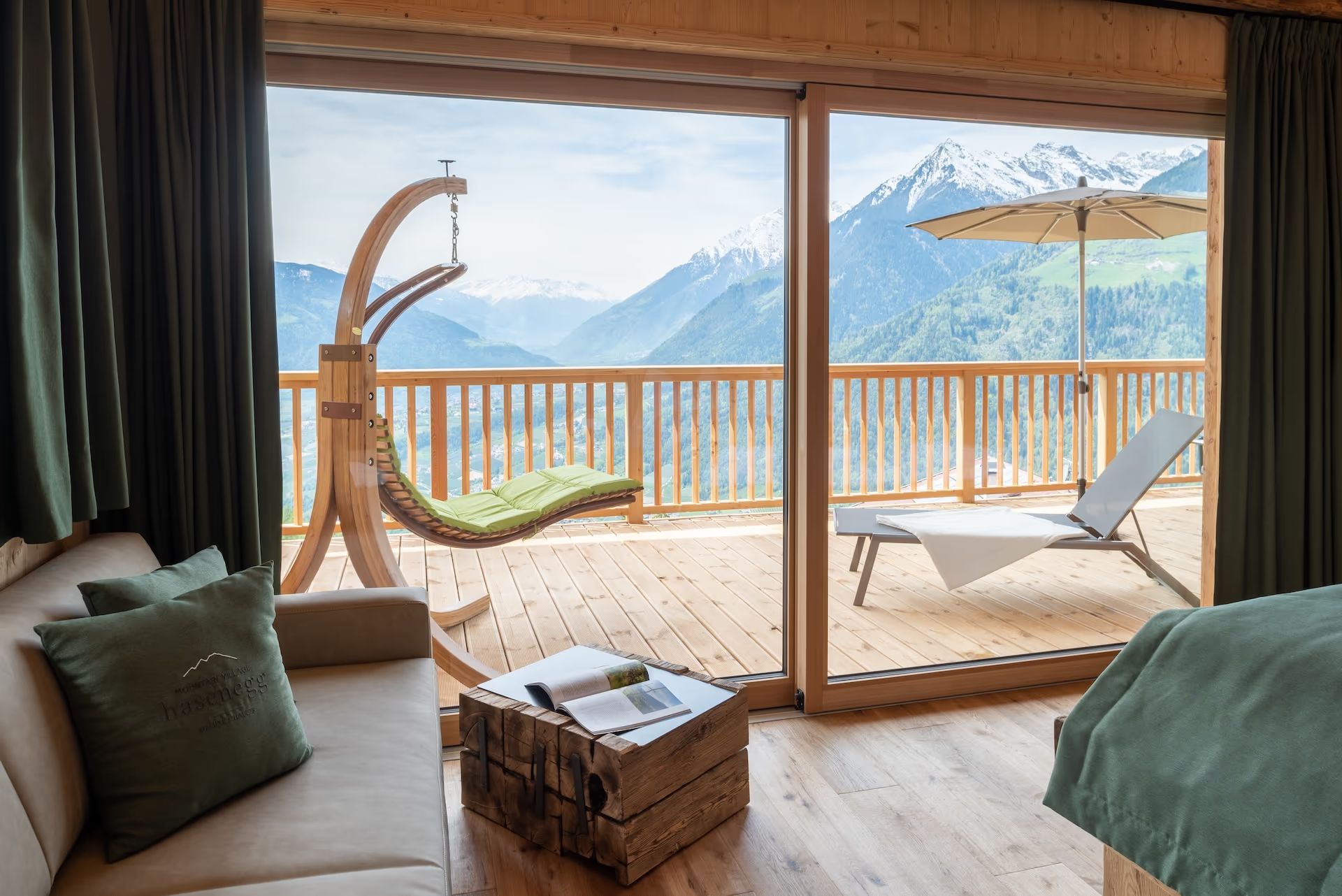 Monte Chalet – Wohnraum mit Terrasse und schneebedecktem Bergpanorama