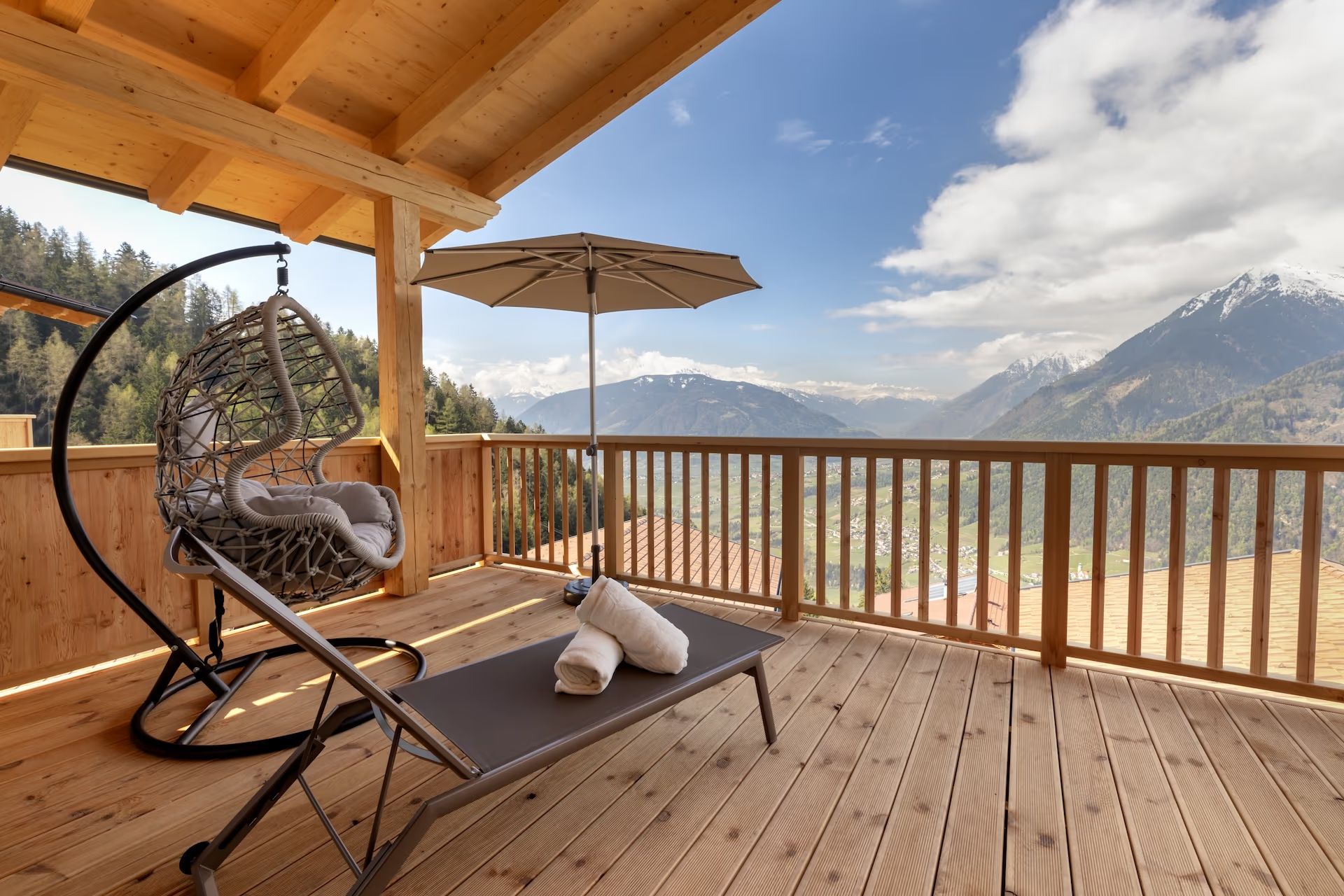 Hängesessel und Liege auf der Chalet-Terrasse mit Bergpanorama