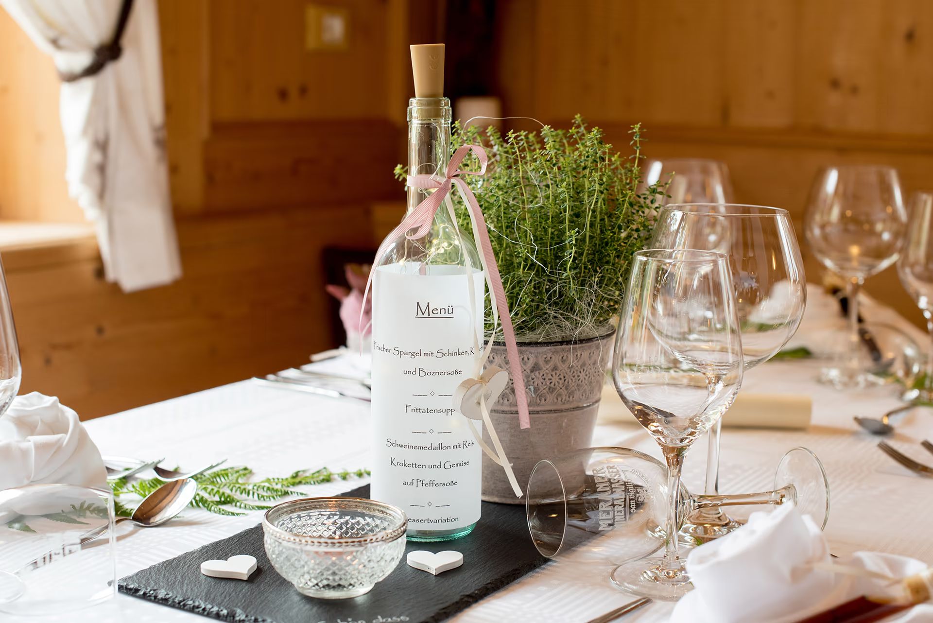 Im Chalet gedeckter Tisch mit Wein, Gläsern und Lavendel
