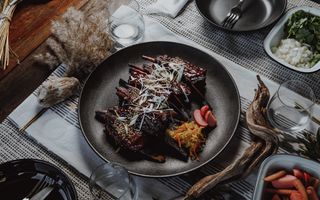 Coconut braised char siu venison ribs on set table