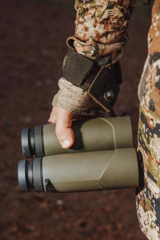 Hunter holding pair of binoculars