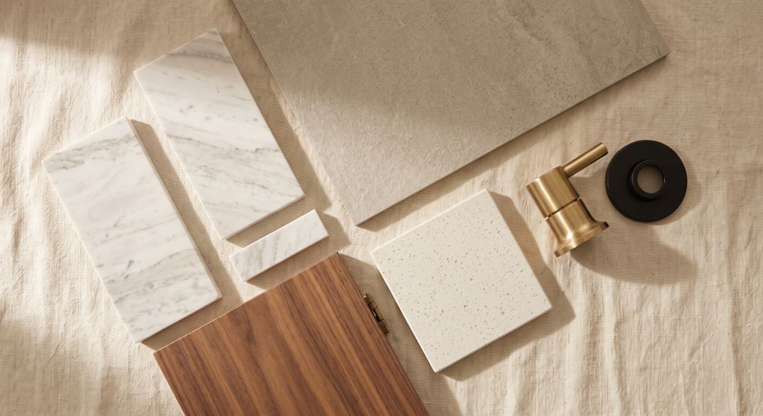 Bathroom material selection with marble tile samples, quartz countertops and custom cabinetry door fronts
