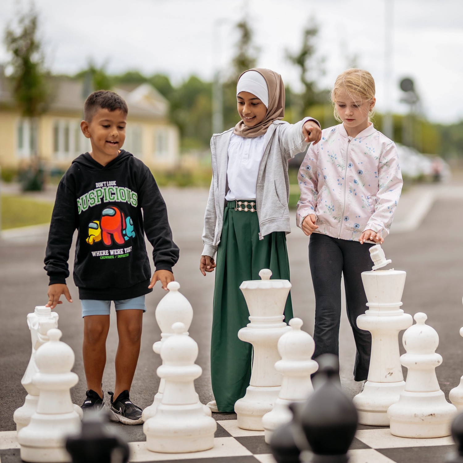 Barn spelar stort schack på gården