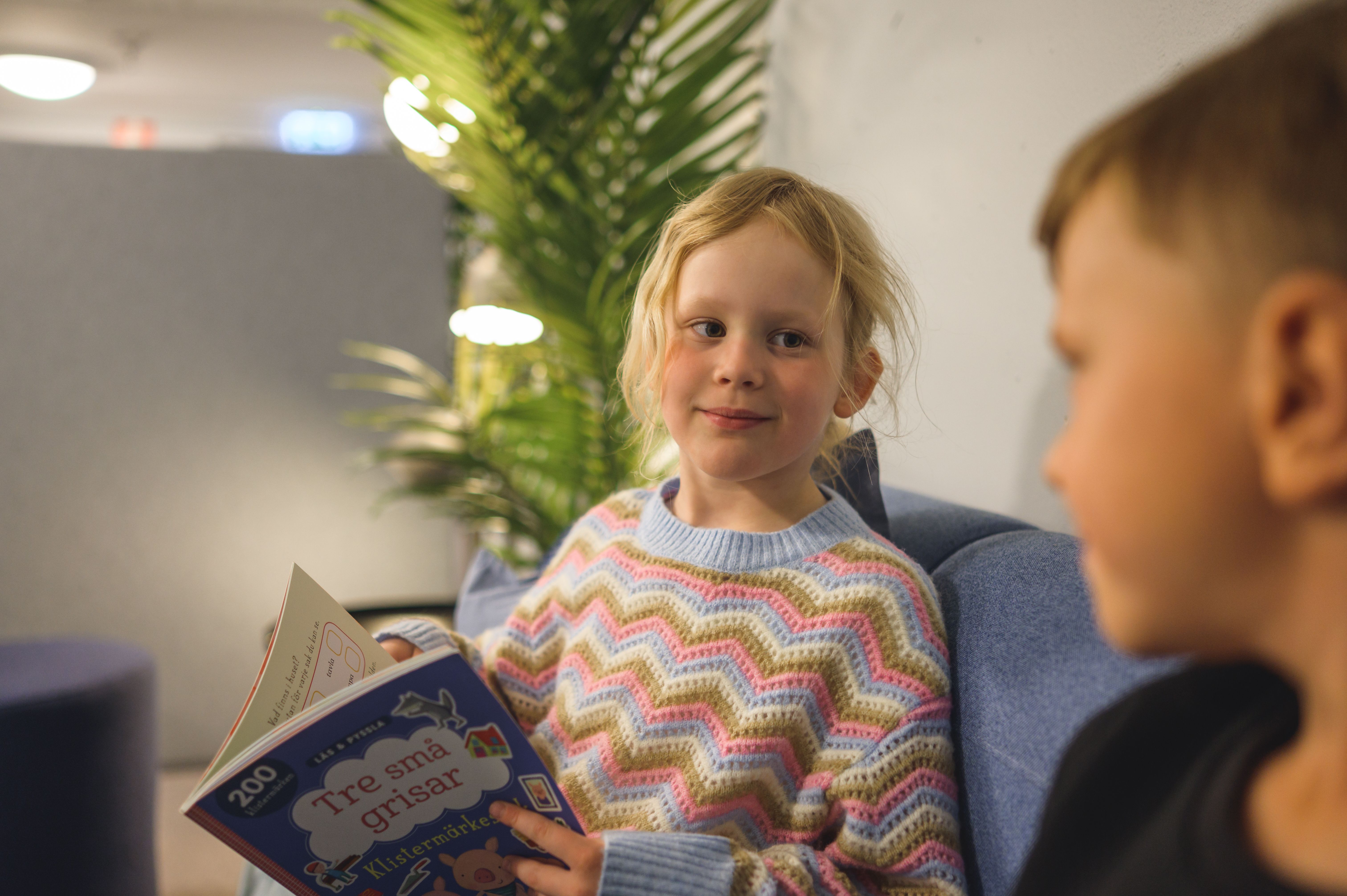 Flicka med bok läser