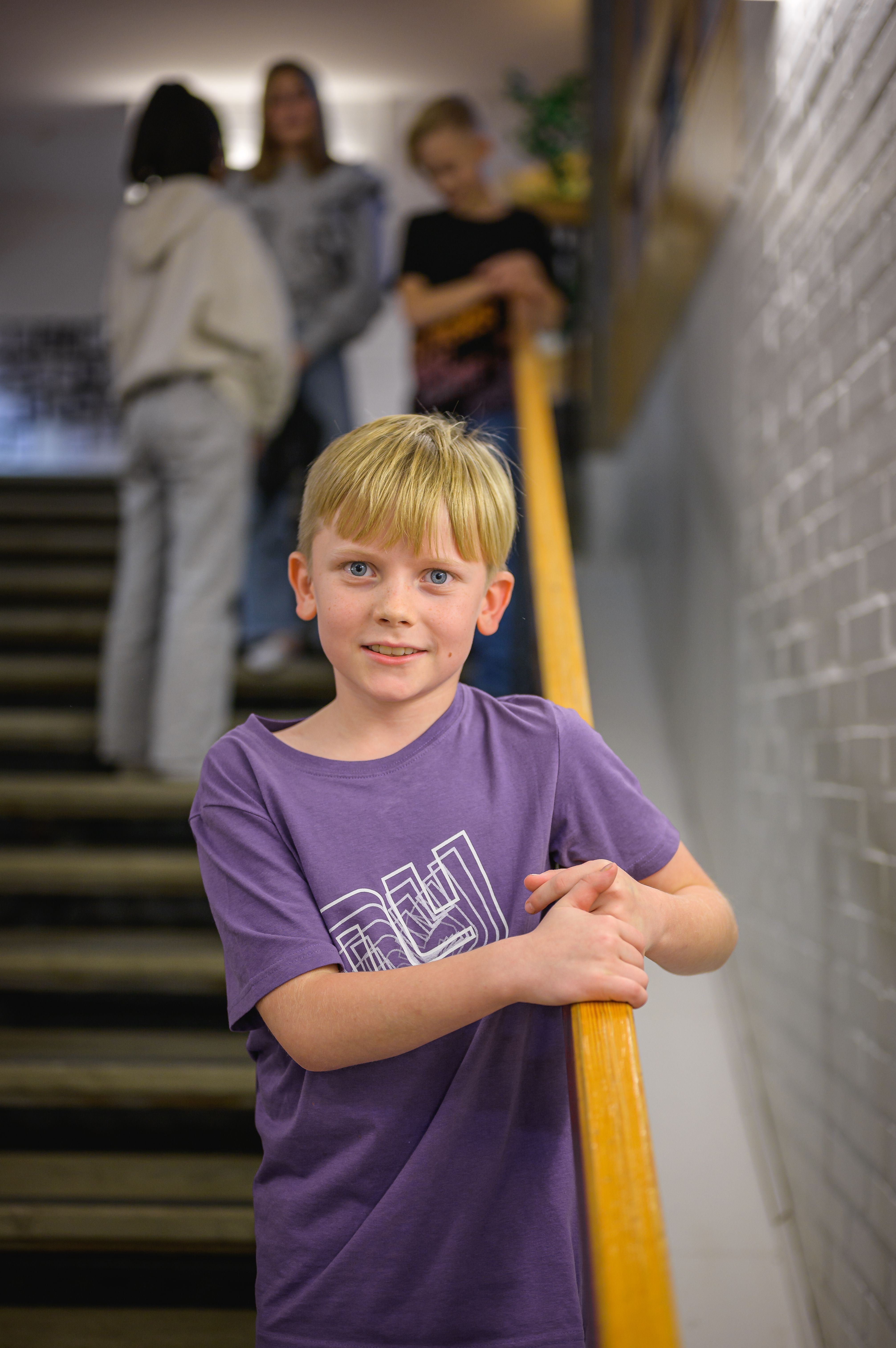 Pojke står i trappa och tittar in i kameran