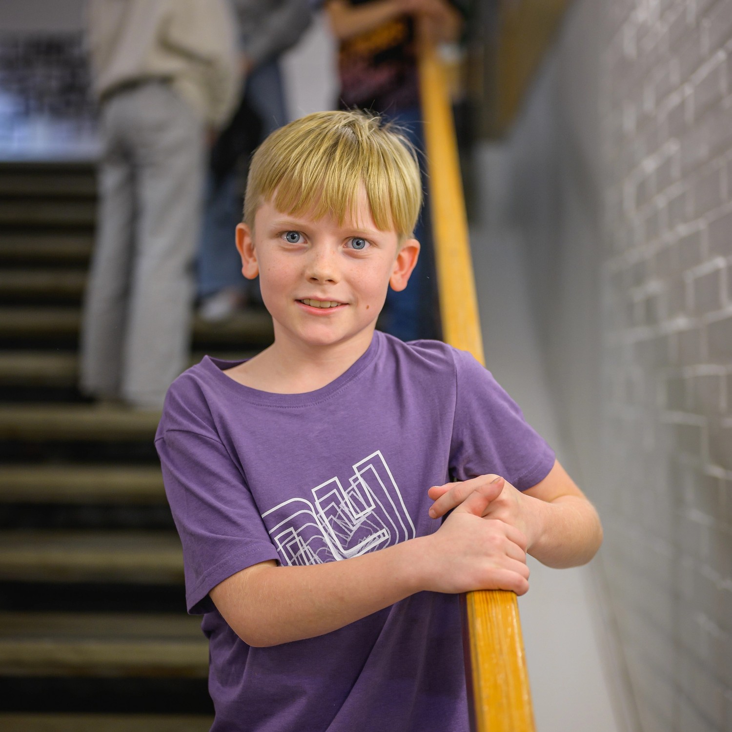 Pojke står i trappa och tittar in i kameran