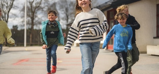 4 barn kommer gående mot kameran skrattande