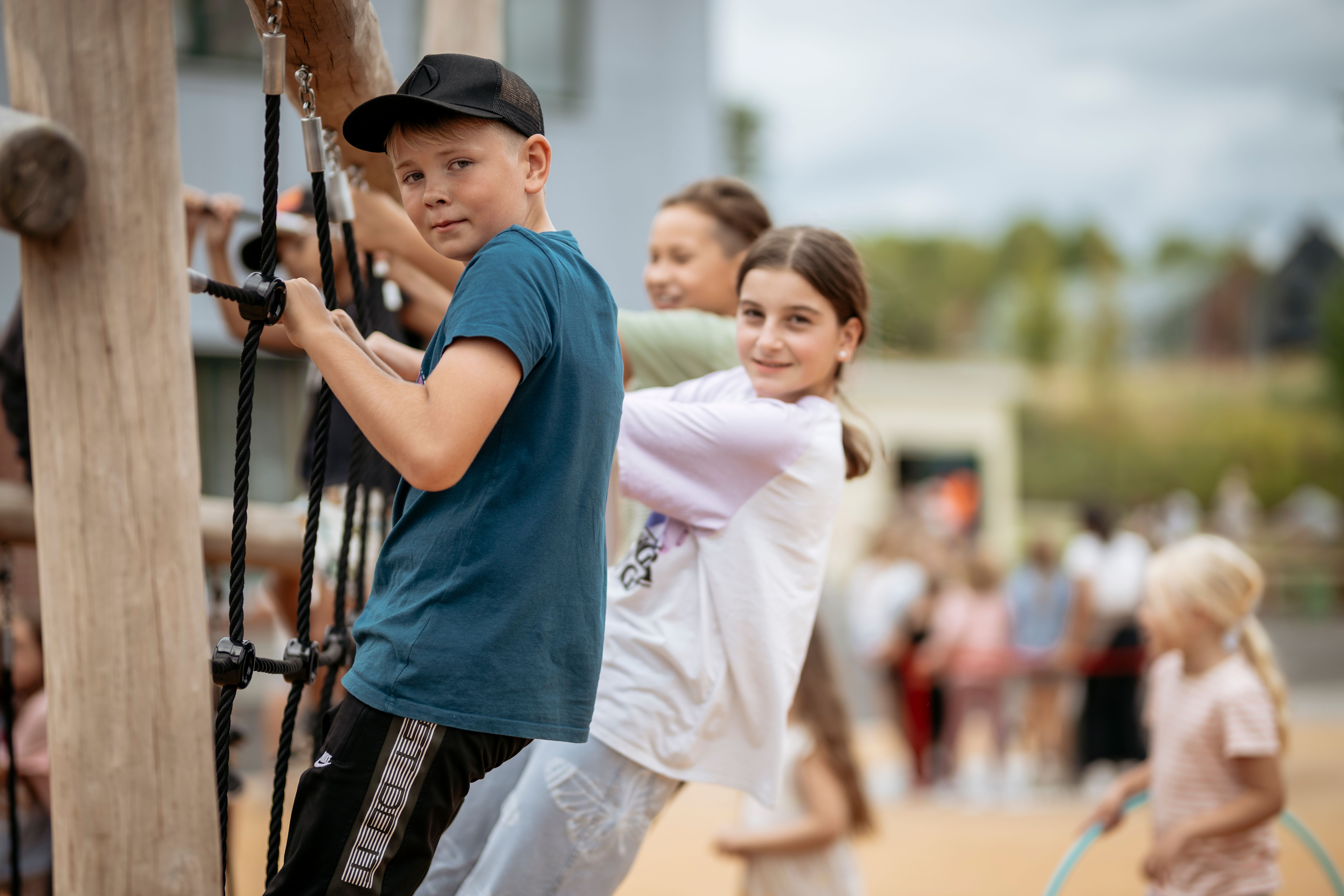 Tre barn klättrar i klätterställning