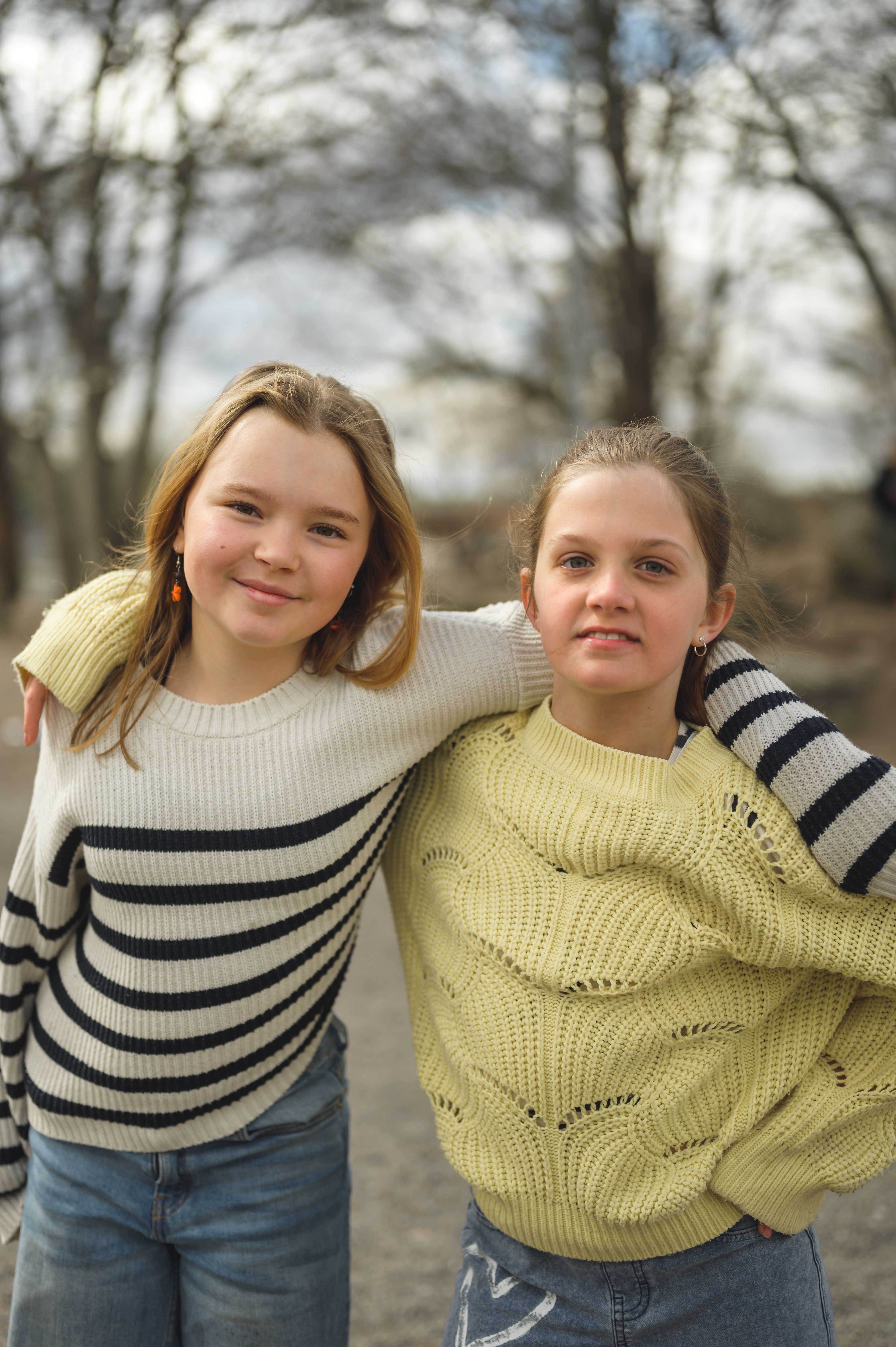 två tjejer håller varandra om axlarna utomhus