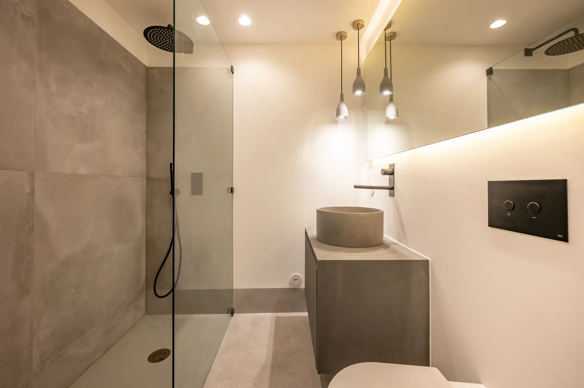 Casa de banho minimalista com revestimentos em tons pedra, base de duche em vidro e lavatório em microcimento
