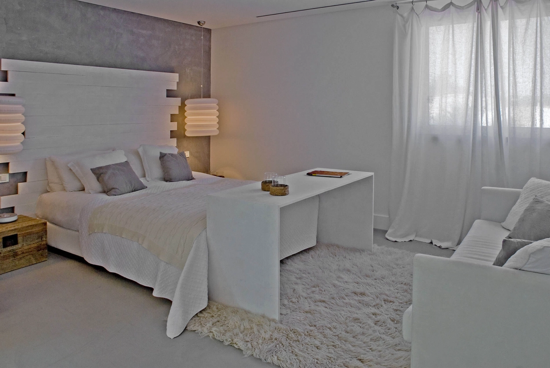 Quarto com cabeceira em ripado de madeira branca, parede em microcimento e tapete de pelo — design de interiores de luxo Tróia, Setúbal