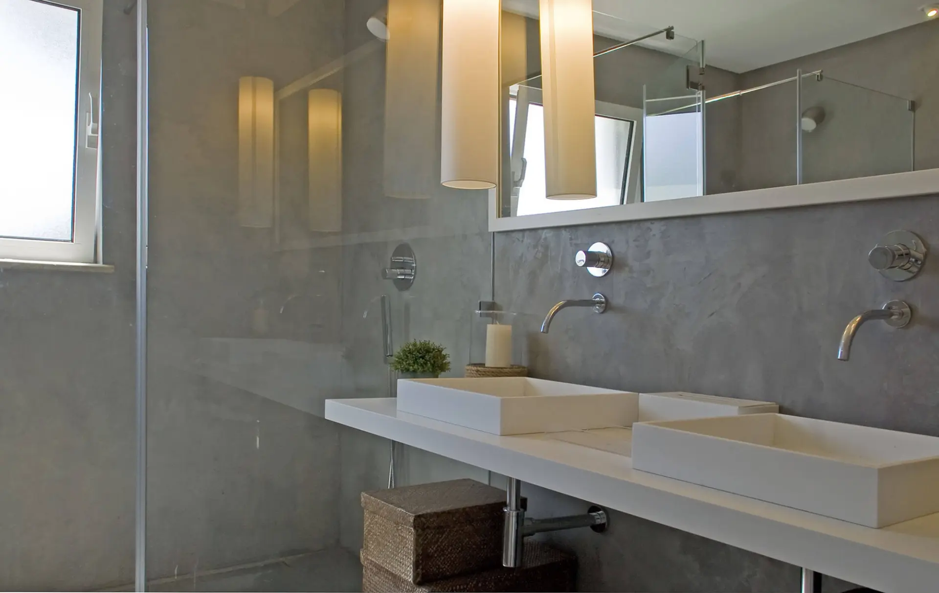 Casa de banho em microcimento com lavatórios duplos e candeeiros cilíndricos — design de interiores de luxo Tróia, Setúbal