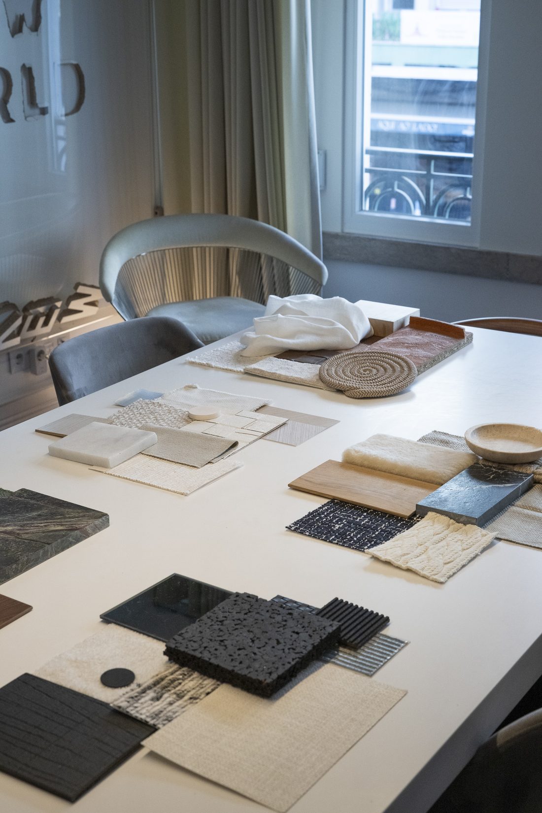 Amostras de pedra, madeira e tecidos sobre a mesa do atelier, em Lisboa