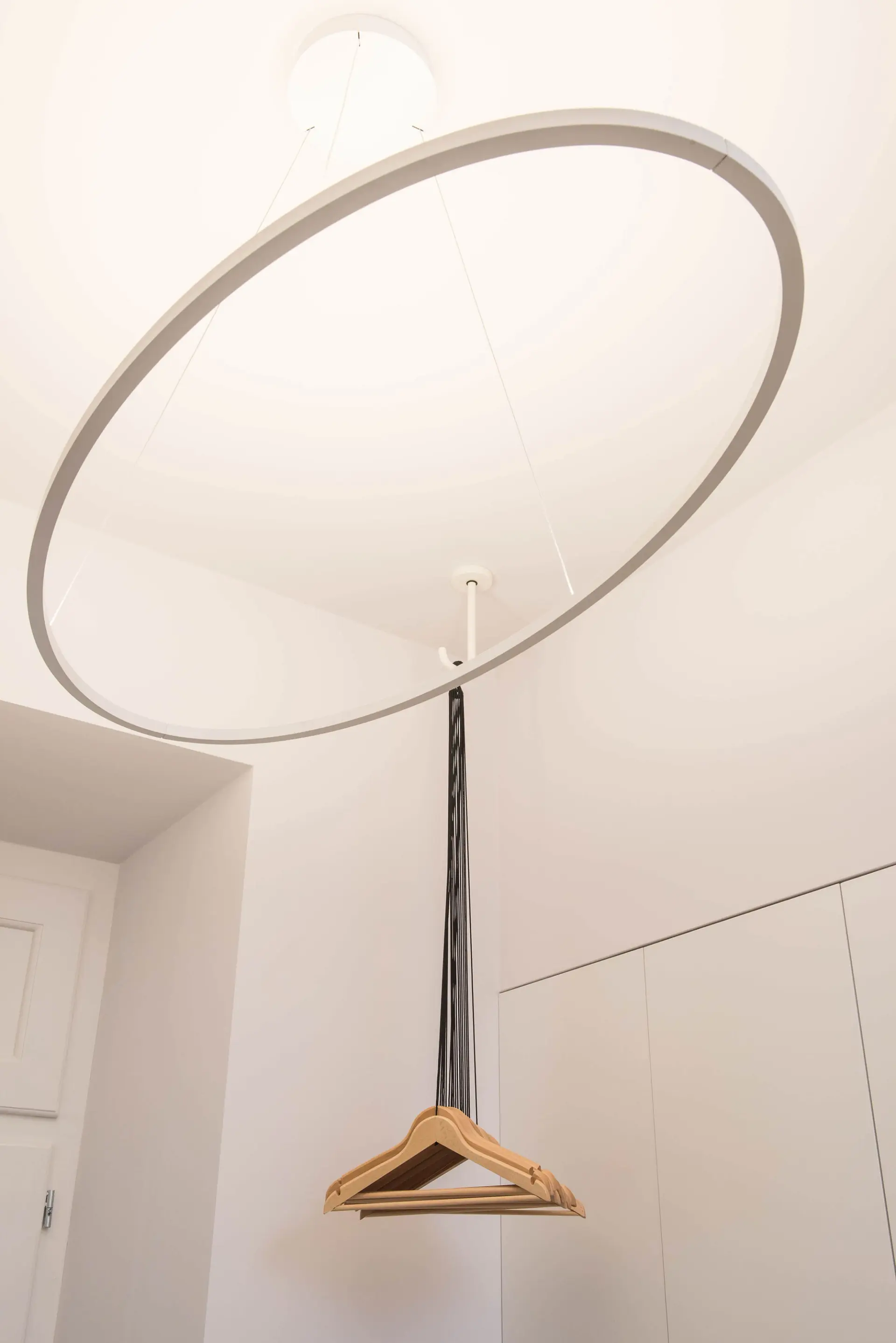 Detalhe de hall com pendente circular Nemo Ellisse Major e sistema de cabides Ligne Roset Coat Rack — design de interiores de luxo, Lisboa, Atelier Renata Santos Machado