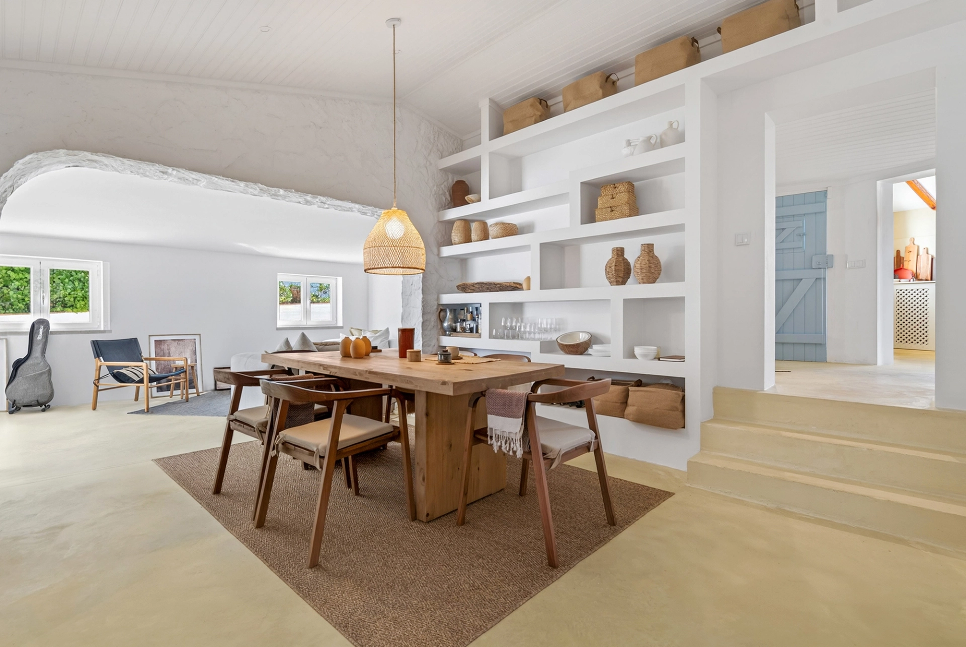 Sala de jantar remodelada com mobiliário em madeira e estantes por medida, num projeto de design de interiores.