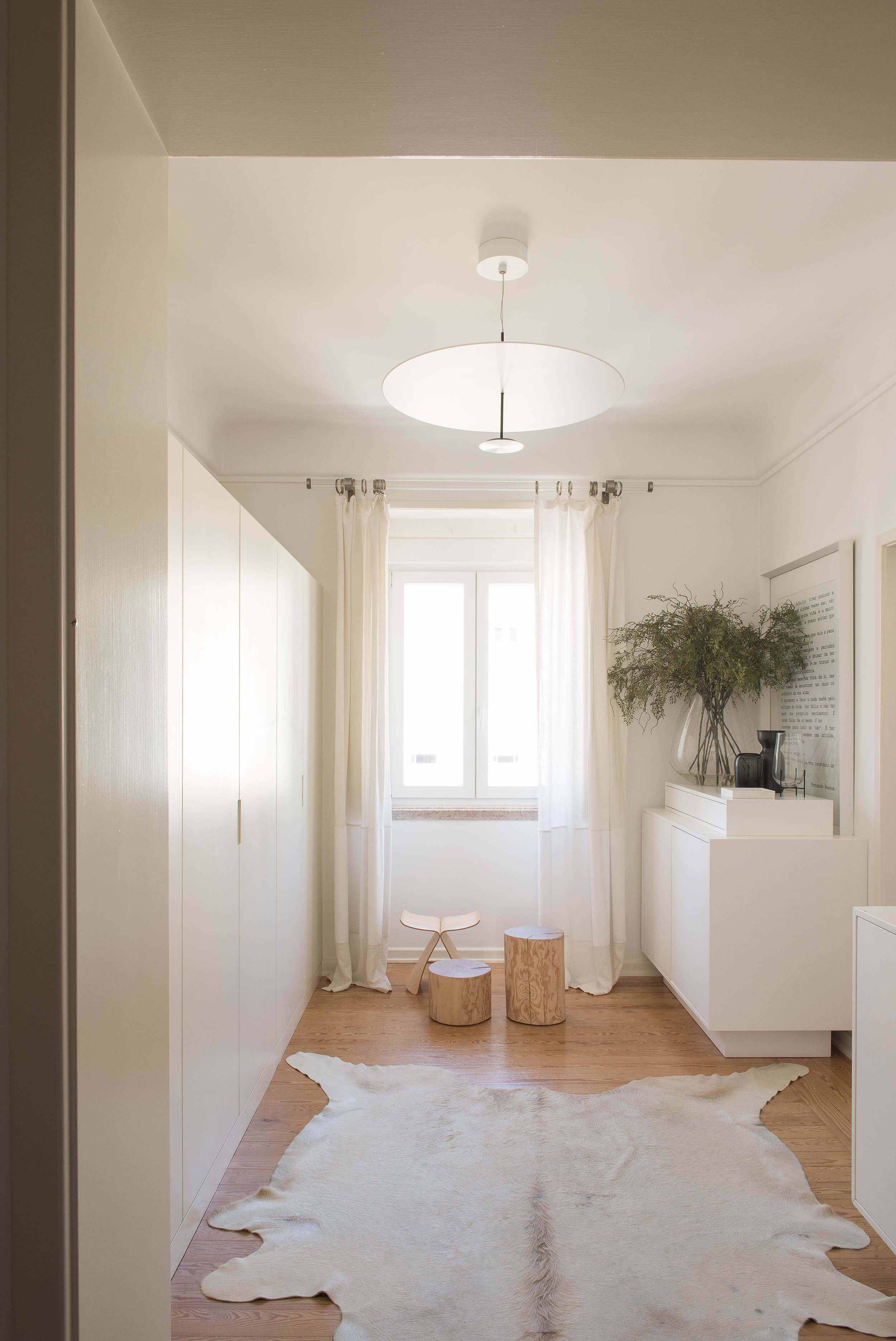 Closet com pendente circular Lumina, tapete de pele de vaca e roupeiros brancos embutidos — design de interiores de luxo, Avenidas Novas, Lisboa, Atelier Renata Santos Machado