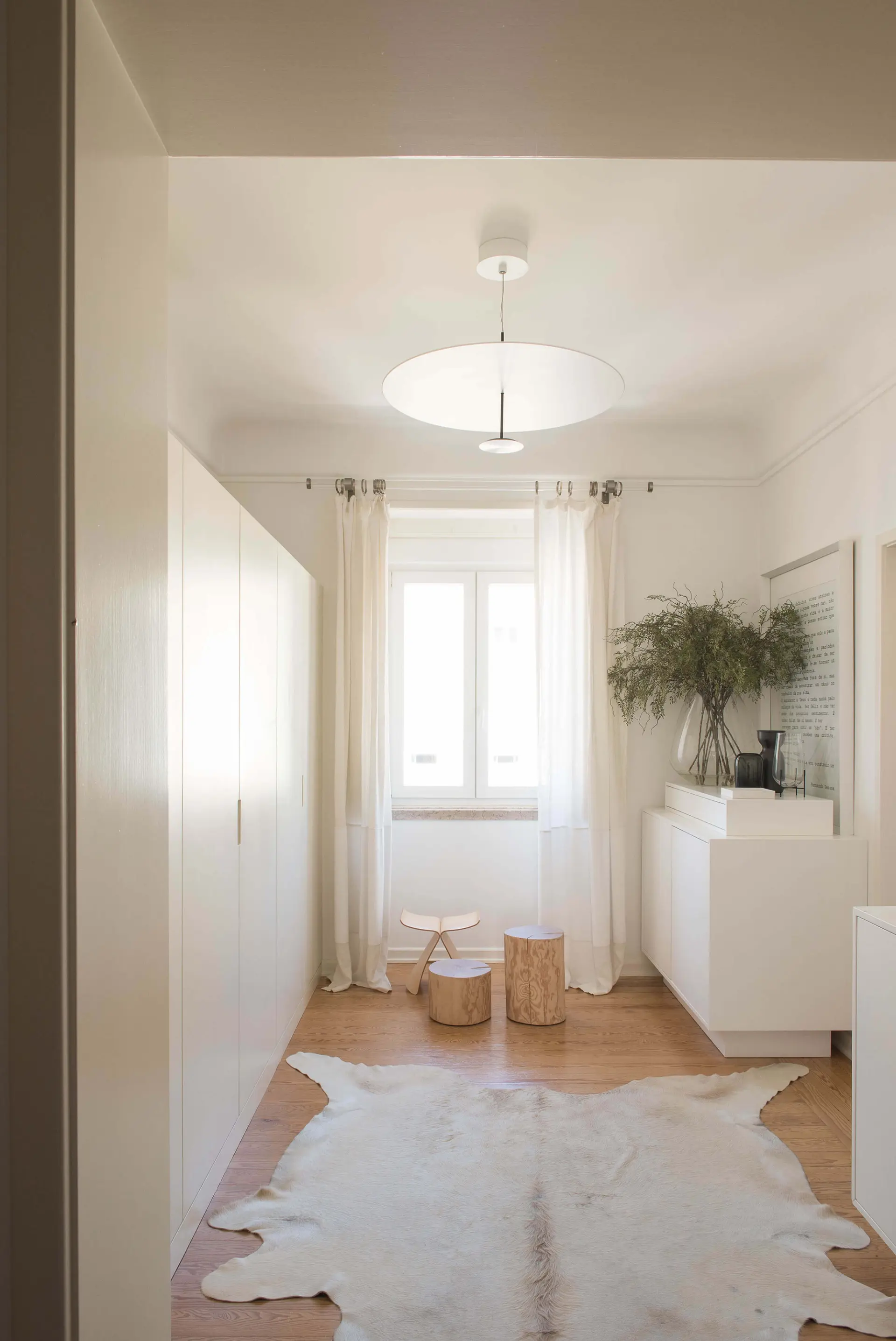 Closet com pendente circular Lumina, tapete de pele de vaca e roupeiros brancos embutidos — design de interiores de luxo, Avenidas Novas, Lisboa, Atelier Renata Santos Machado