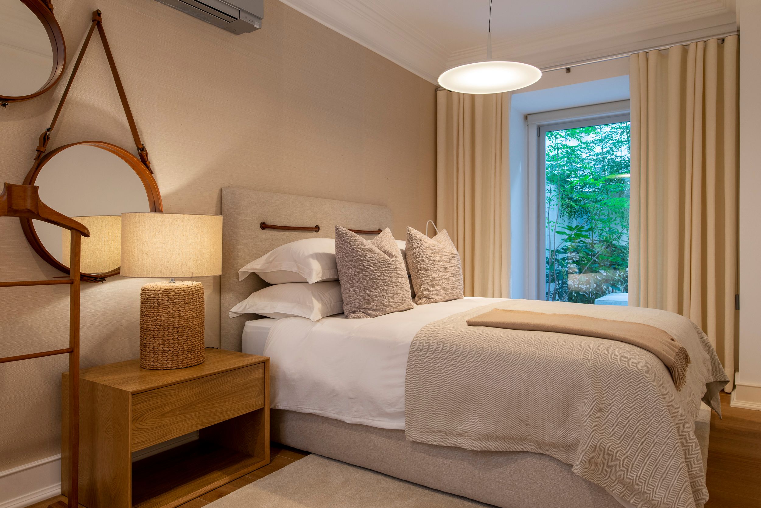 Quarto com projeto de design de interiores em tons neutros e materiais naturais