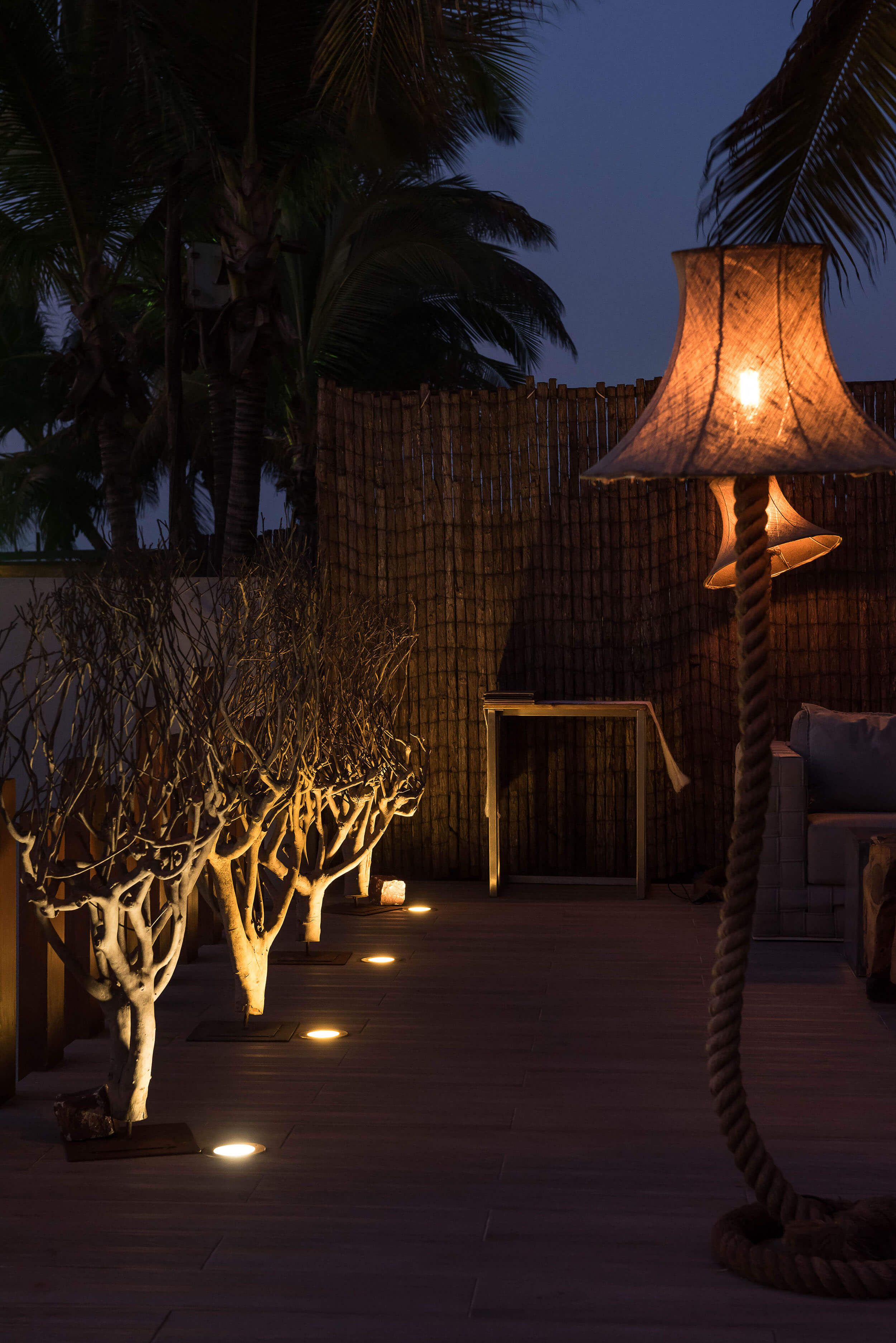 Candeeiro de pé com base em corda e árvores decorativas iluminadas — design de interiores de restaurante de luxo Luanda, Angola