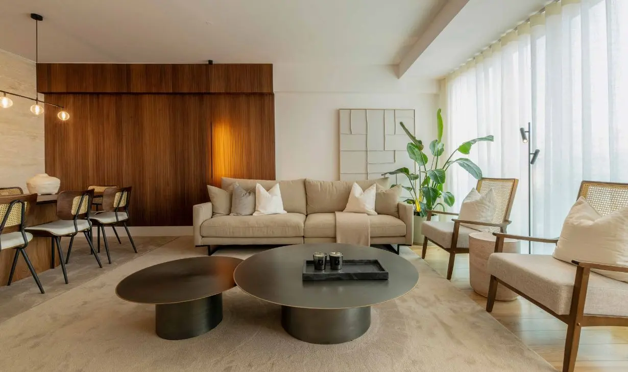 Open-plan living room interior design project in Portugal with warm wood paneling, contemporary furniture and soft natural light by Atelier Renata Santos Machado.