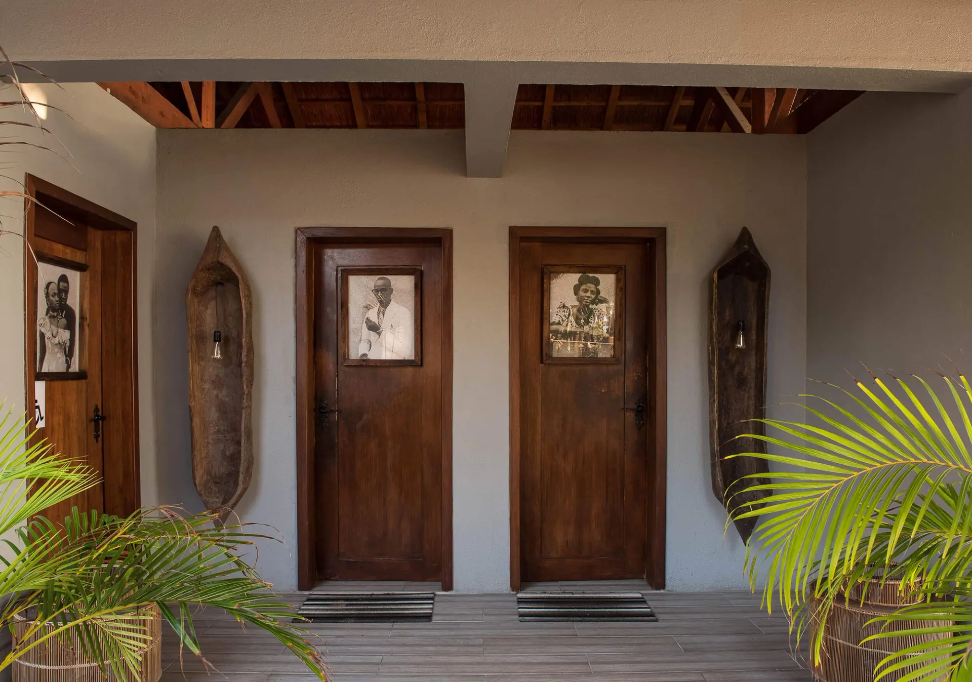 Casas de banho com portas de madeira, fotografia vintage e esculturas — design de interiores de restaurante de luxo Luanda, Angola