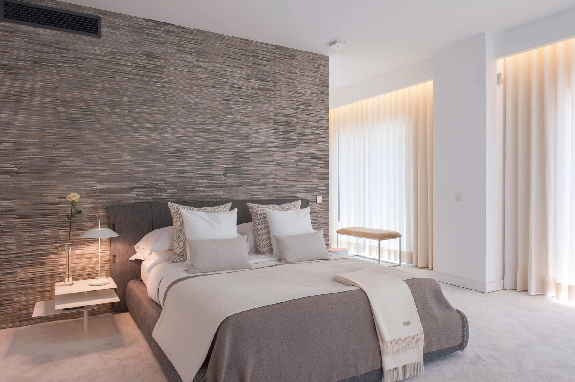 Master suite com cama Bonaldo Fluff cinzenta, parede pedra Tasmania e alcatifa branca — design de interiores de luxo Paço de Arcos, Oeiras, Atelier Renata Santos Machado