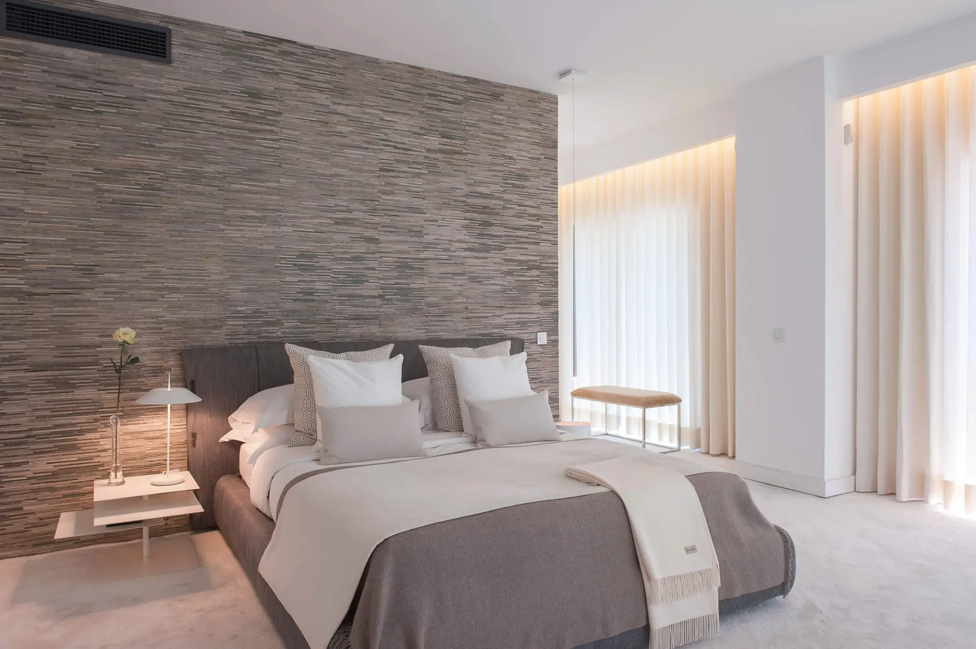 Master suite com cama Bonaldo Fluff cinzenta, parede pedra Tasmania e alcatifa branca — design de interiores de luxo Paço de Arcos, Oeiras, Atelier Renata Santos Machado