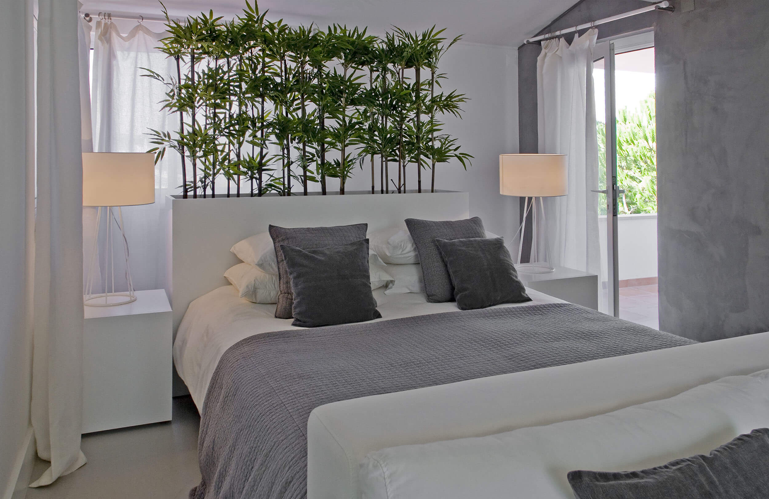 Quarto com cabeceira branca e canteiro de bambu integrado e almofadas cinzentas — design de interiores de luxo Tróia, Setúbal
