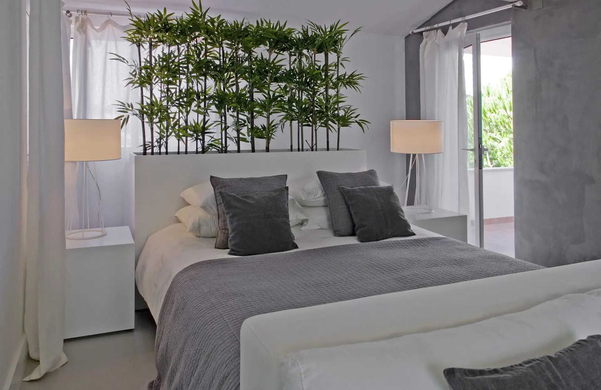 Quarto com cabeceira branca e canteiro de bambu integrado e almofadas cinzentas — design de interiores de luxo Tróia, Setúbal