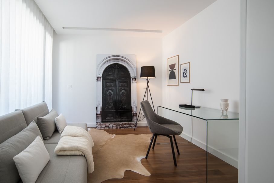 Espaço de trabalho integrado em apartamento contemporâneo com decoração neutra, consola em vidro, iluminação suave e styling minimalista.