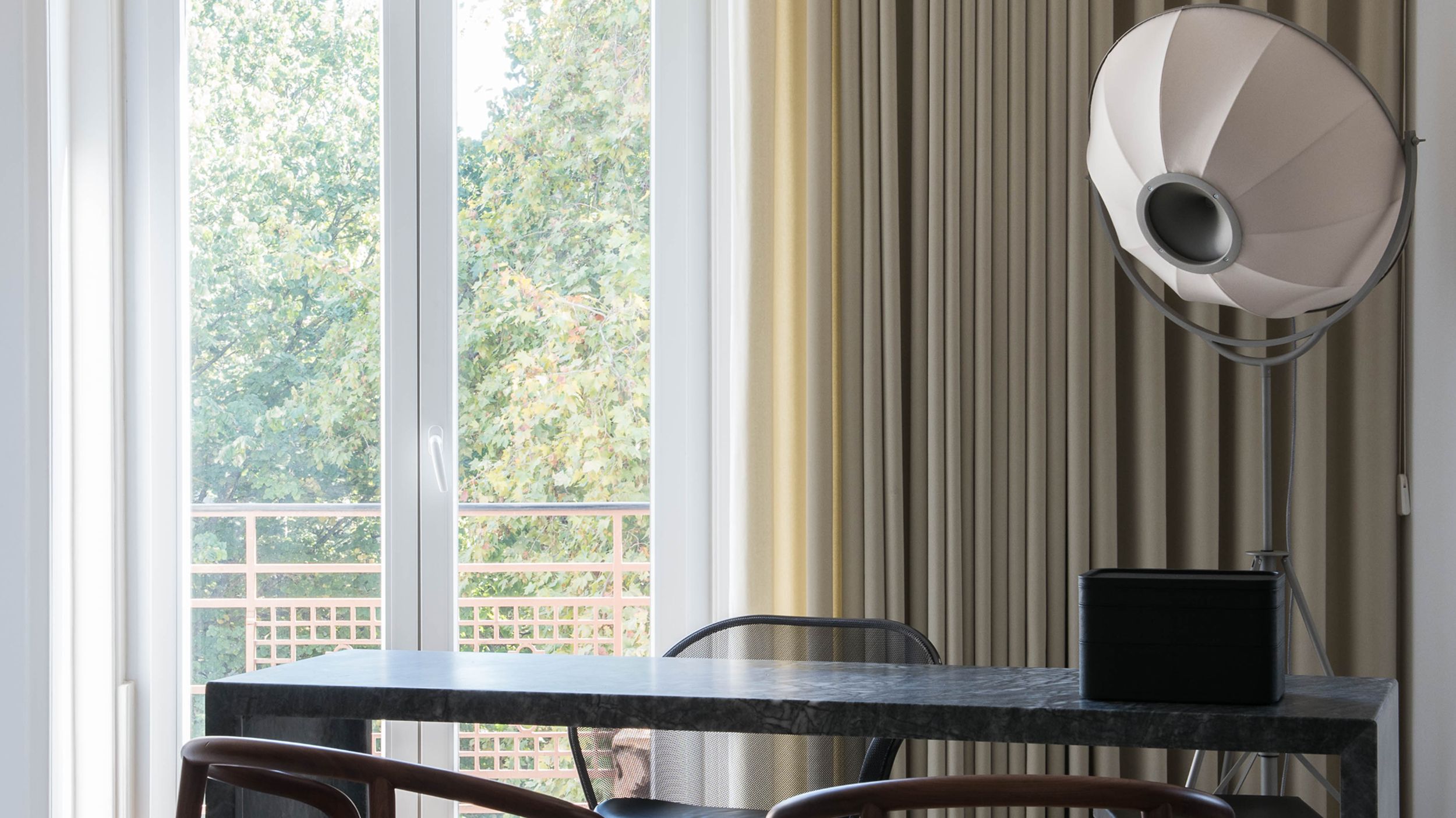 Elegant and luxurious office with a dark Marquina stone desk and wooden chairs with cane seats.