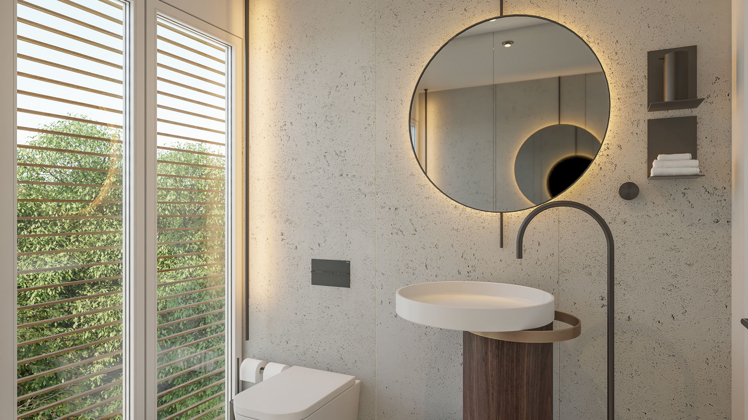 Oval stone basin, a floor-mounted arc tap and a backlit round mirror on a microcement wall by louvred shutters — luxury bathroom