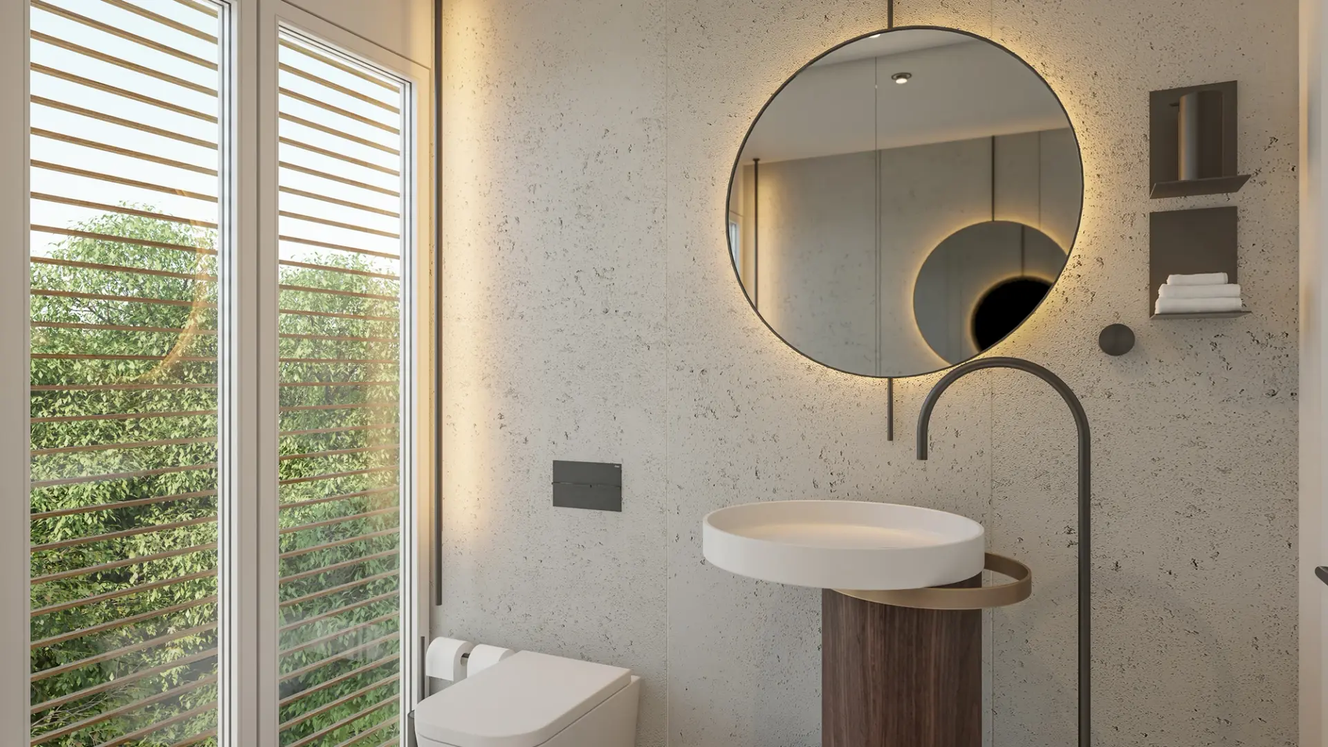 Oval stone basin, a floor-mounted arc tap and a backlit round mirror on a microcement wall by louvred shutters — luxury bathroom
