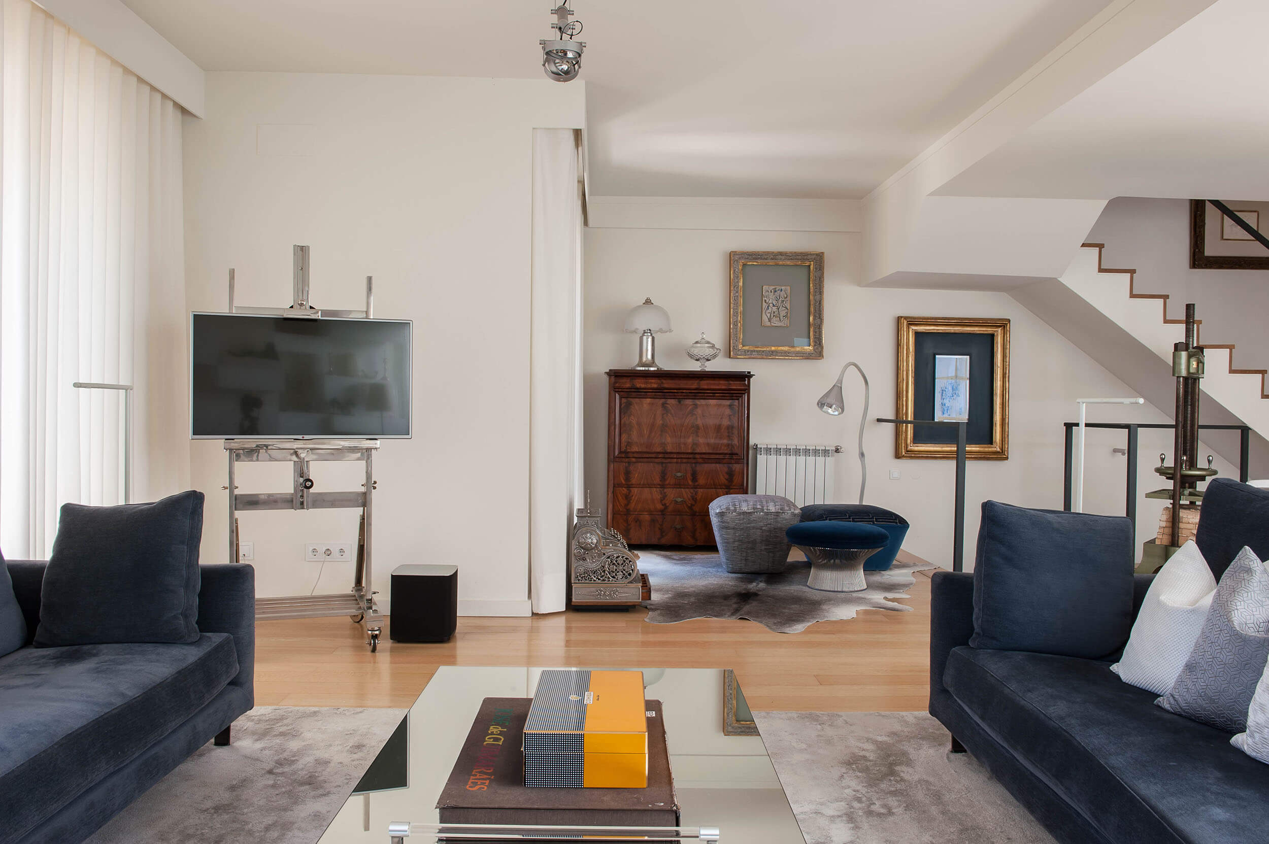 Sala de estar ampla e luminosa com tons neutros. Projeto de design de interiores na linha de Cascais adaptado à escala e à luz natural