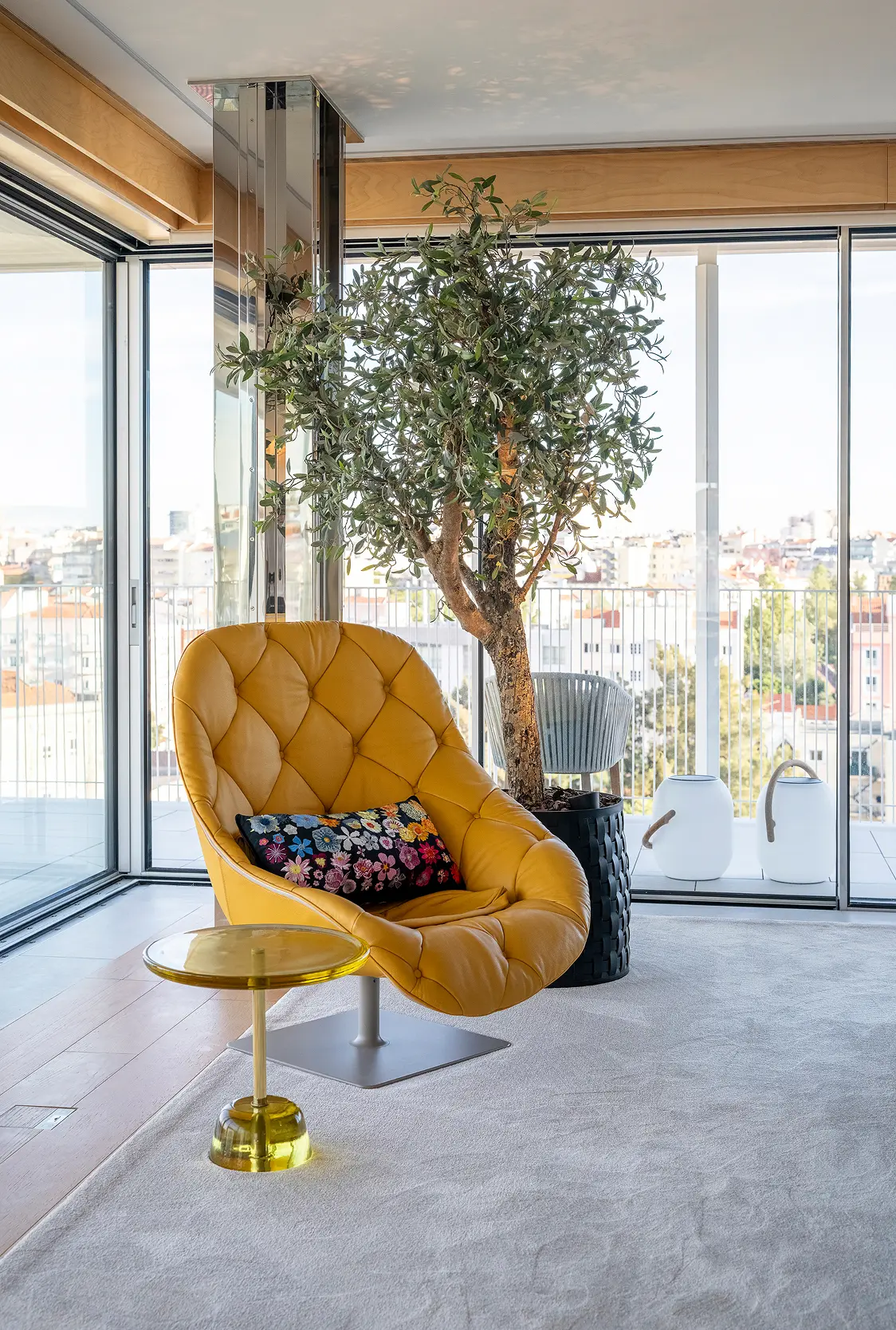 Poltrona em veludo mostarda com mesa de apoio em latão dourado e oliveira natural em sala de estar com vista sobre Lisboa — design de interiores de luxo na Praça de Espanha, Lisboa, Atelier Renata Santos Machado
