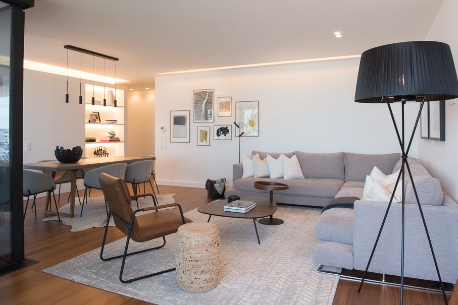 Sala de estar contemporânea preparada para homestaging com sofá modular neutro, iluminação elegante e decoração minimalista.