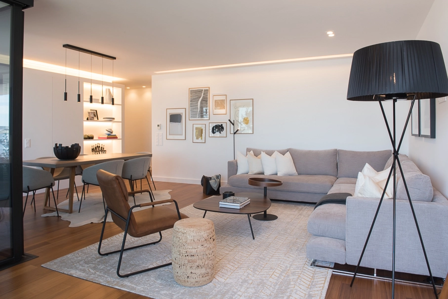 Sala de estar contemporânea preparada para homestaging com sofá modular neutro, iluminação elegante e decoração minimalista.