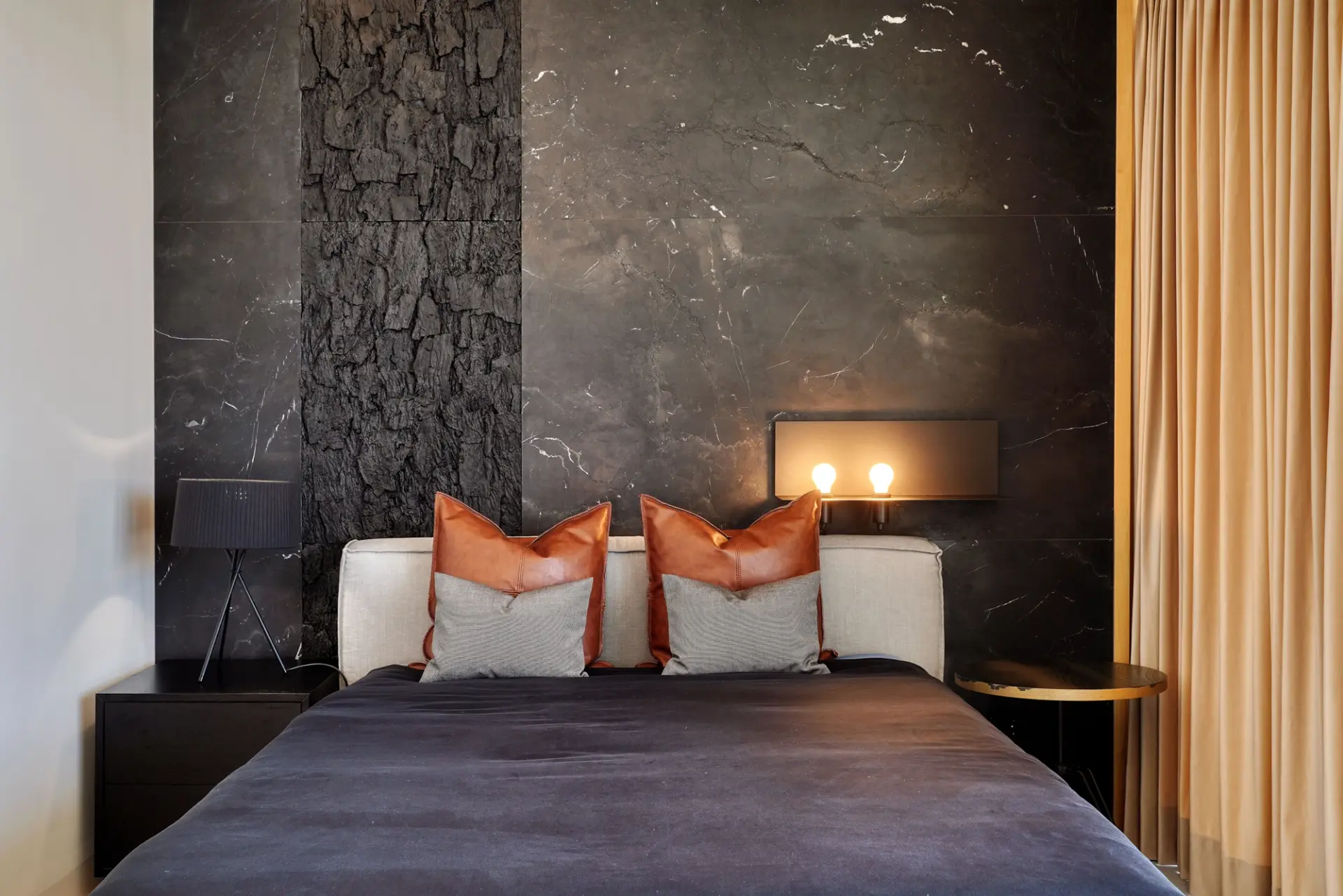 Master suite com mármore negro, painel em madeira carbonizada e almofadas em couro laranja — design de interiores de luxo, Praça de Espanha, Atelier Renata Santos Machado