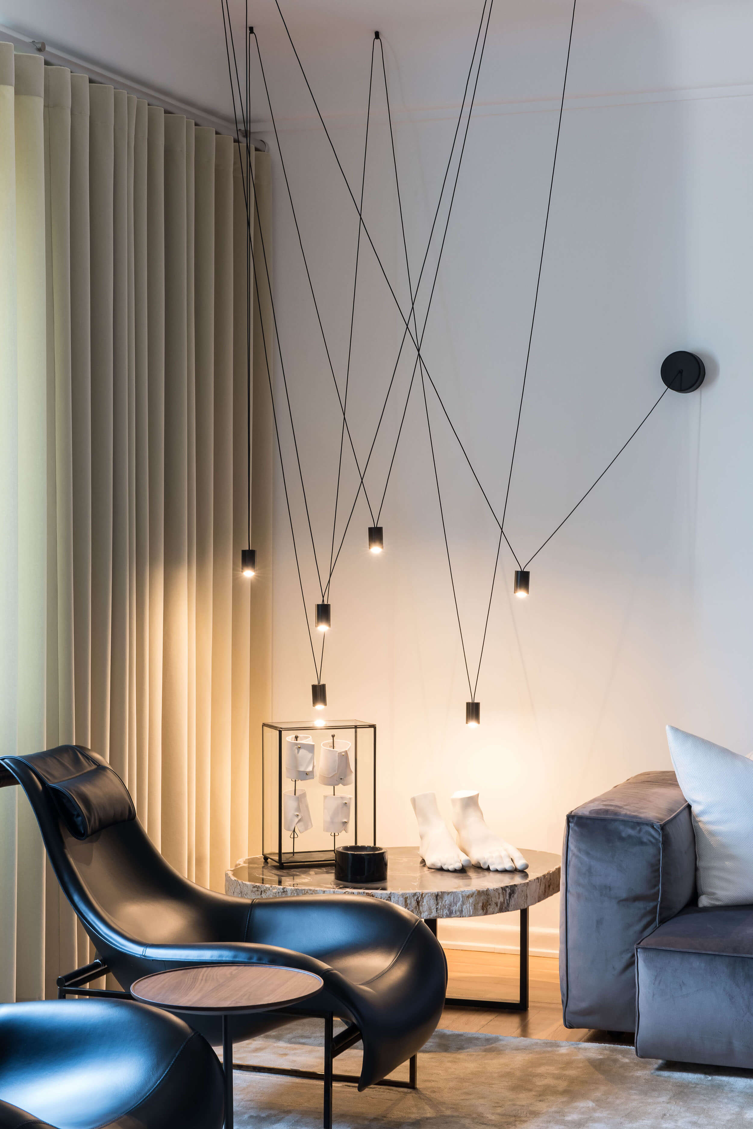 Sala de estar com pendentes VESOI em instalação de cabos e mesa em madeira petrificada — design de interiores de luxo, Avenidas Novas, Lisboa, Atelier Renata Santos Machado