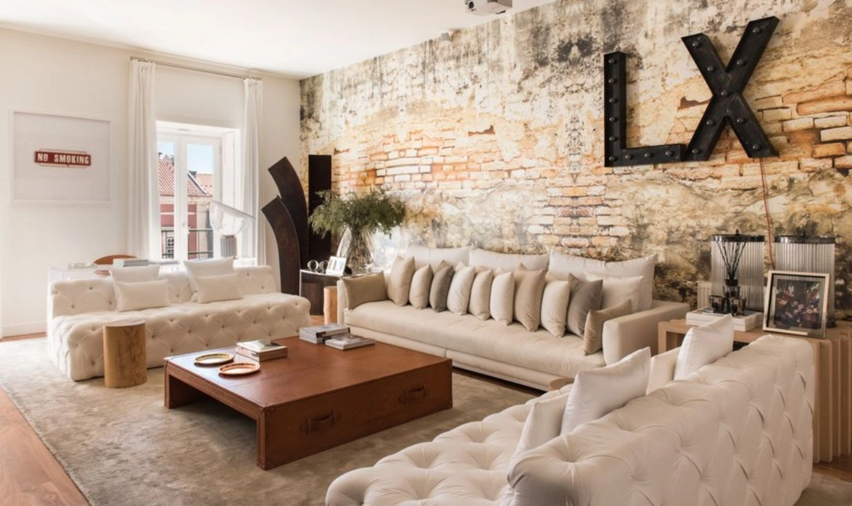 Luxury living room interior design project in Portugal by Atelier Renata Santos Machado, with textured statement wall, neutral sofas, wooden coffee table and layered styling.